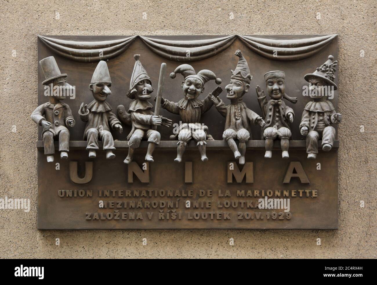 Gedenktafel für die UNIMA (Union Internationale de la Marionnette) auf dem Gebäude des Puppentheaters (Divadlo Říše loutek) in der Žatecká Straße in Staré Město (Altstadt) in Prag, Tschechische Republik. Die Internationale Puppenspielervereinigung wurde in diesem Theater am 20. Mai 1929 gegründet. Traditionelle nationale Marionetten sind auf der Tafel des tschechischen Bildhauers Bohumír Koubek abgebildet, die 1979 enthüllt wurde. Von links nach rechts sind Belgisches Tchantchès, Italienisches Pulcinella, Englisches Punch, Tschechisches Kašpárek, Russisches Petrushka, Französisches Guignol und Deutsches Kasperl abgebildet. Stockfoto