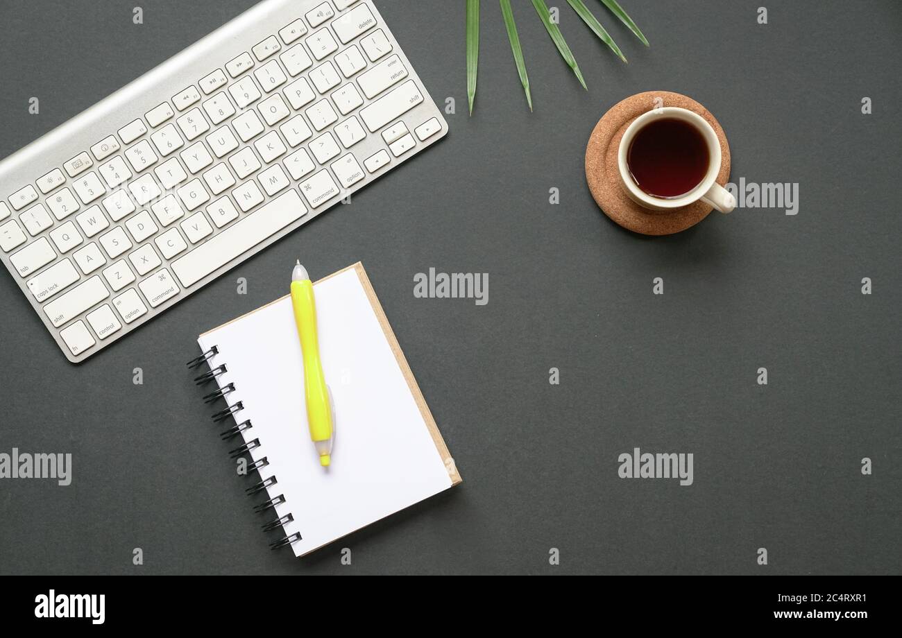 Ansicht von oben auf den Schreibtisch oder flache Tastatur, Kaffee und Notizblock mit Stift. Speicherplatz kopieren. Stockfoto