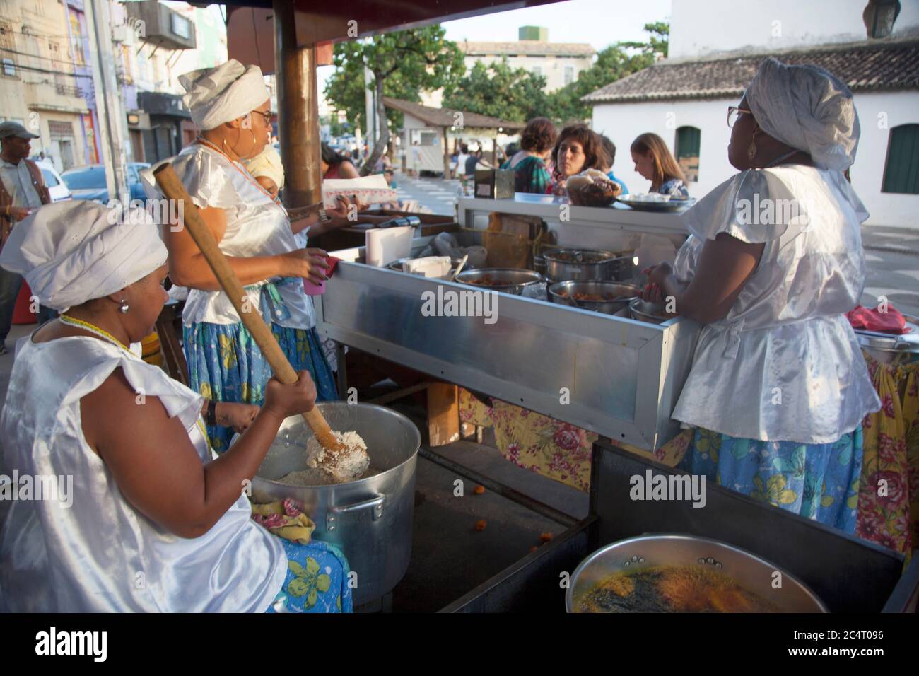 Straßenverkäufer, die bekannt sind, machen Acarajé, ein Gericht aus pürierten und gebratenen Erbsen mit schwarzen Augen, gefüllt mit Garnelen in Salvador de Bahia, Brasilien. Stockfoto