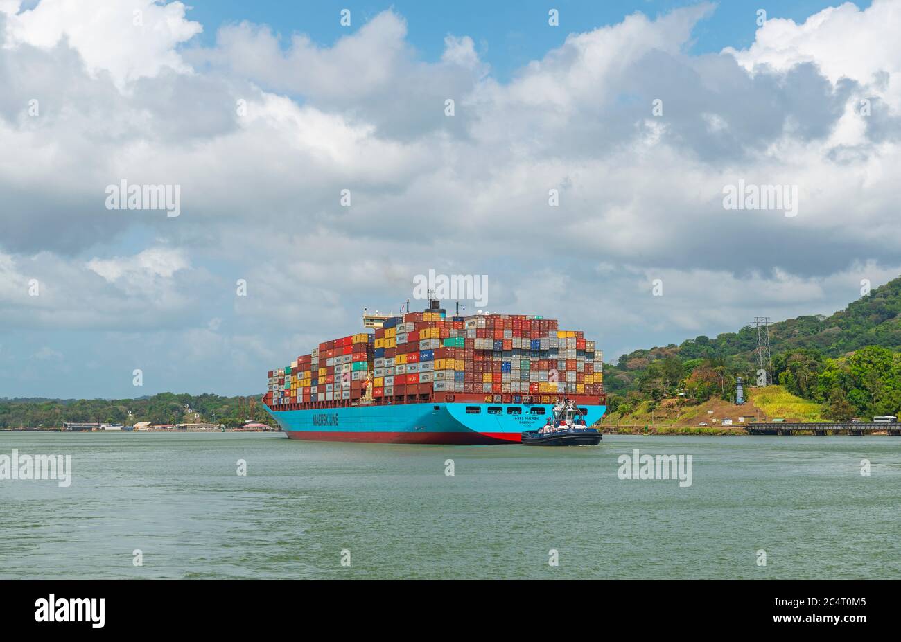 Ein großes Containerschiff mit Fracht, das tagsüber durch den Panamakanal in der Nähe der Schleusen von Miraflores, Panama, fährt. Stockfoto