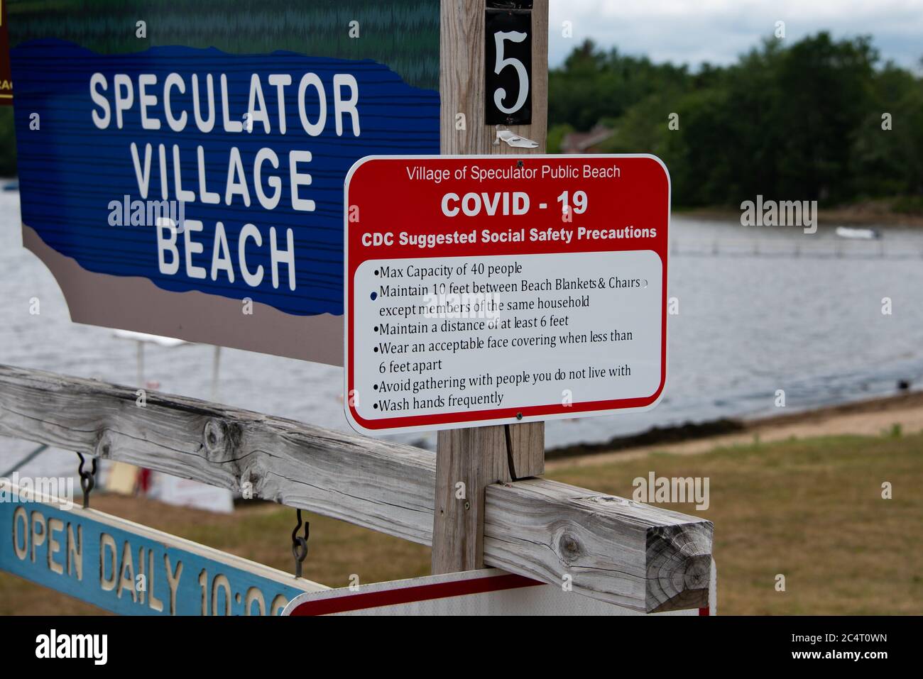 Eine Warnung auf dem Speculator, NY USA Village Beach mit CDC schlug Richtlinien für soziale Sicherheit bezüglich COVID-19 Vorsichtsmaßnahmen vor. Stockfoto