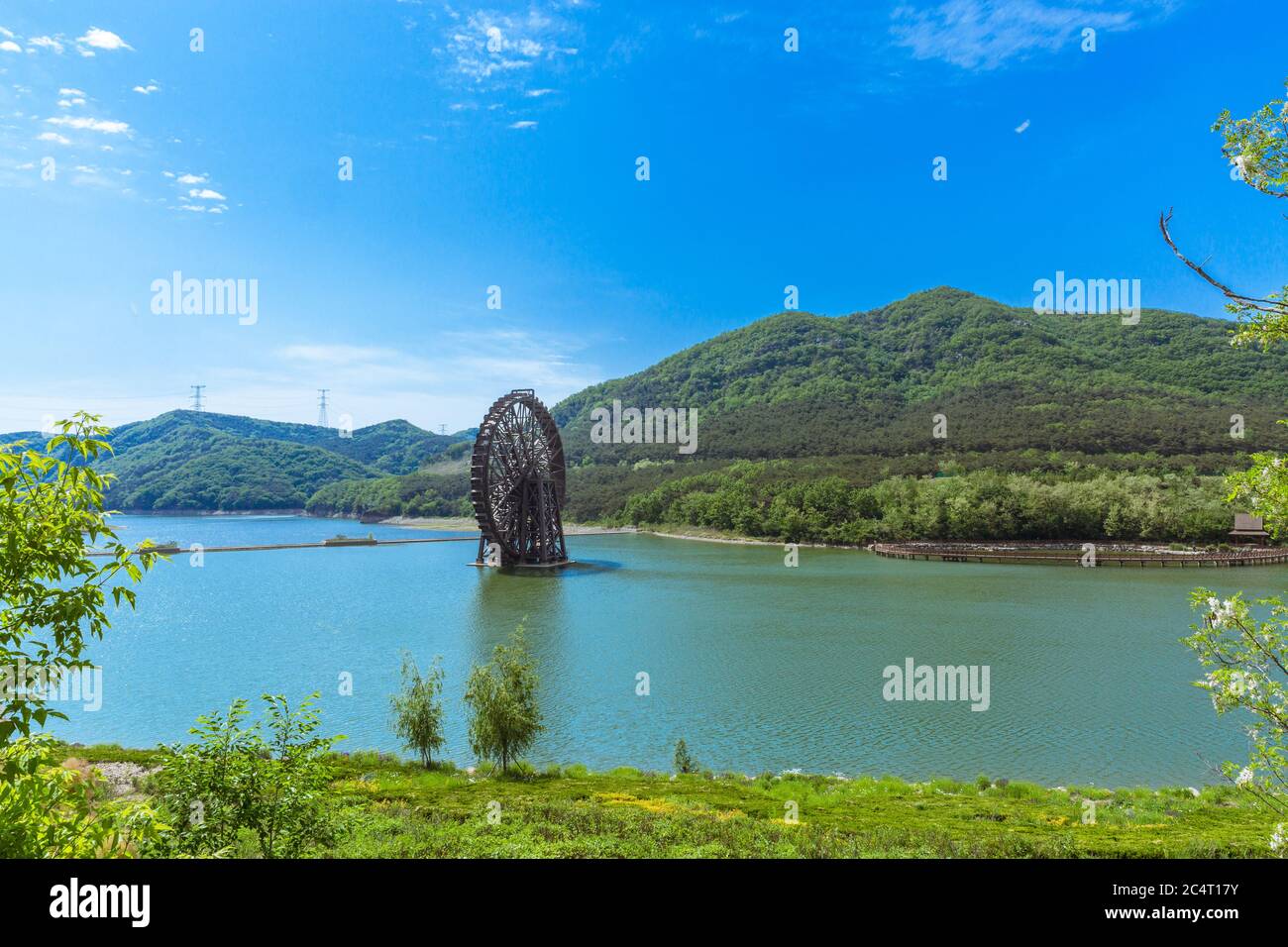 Großes hölzernes Wasserrad und blaues Wasser, Xijiao National Forest Park, Dalian, China Stockfoto