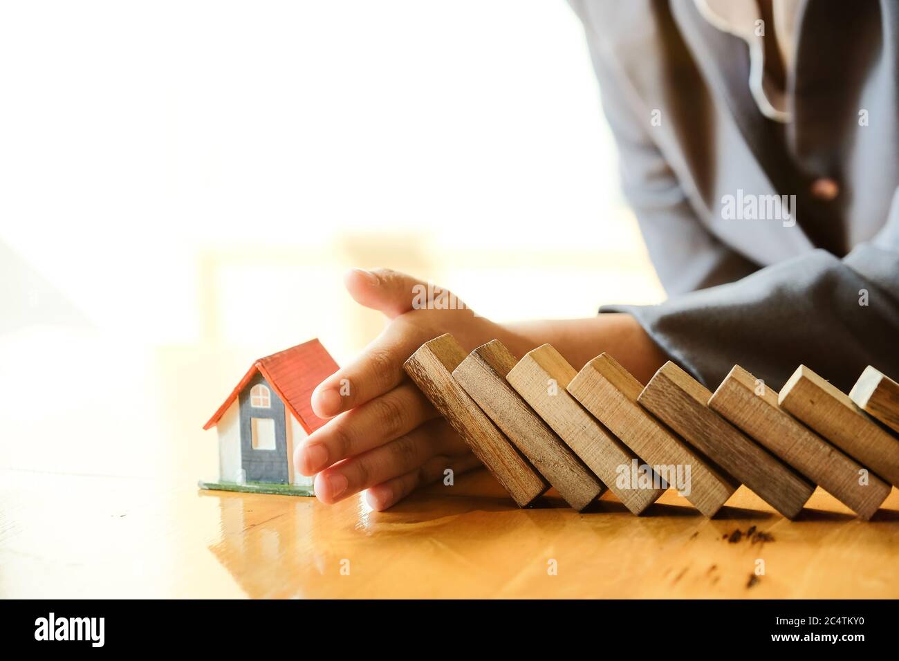 Schützen Sie das Haus vor dem Sturz über die Holzblöcke, Versicherung und Risiko-Konzept. Stockfoto