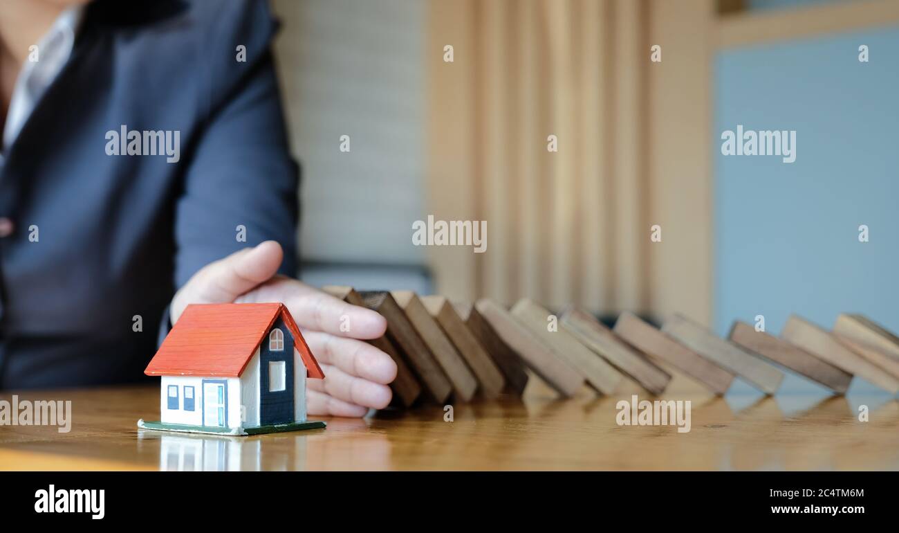 Schützen Sie das Haus vor dem Sturz über die Holzblöcke, Versicherung und Risiko-Konzept. Stockfoto