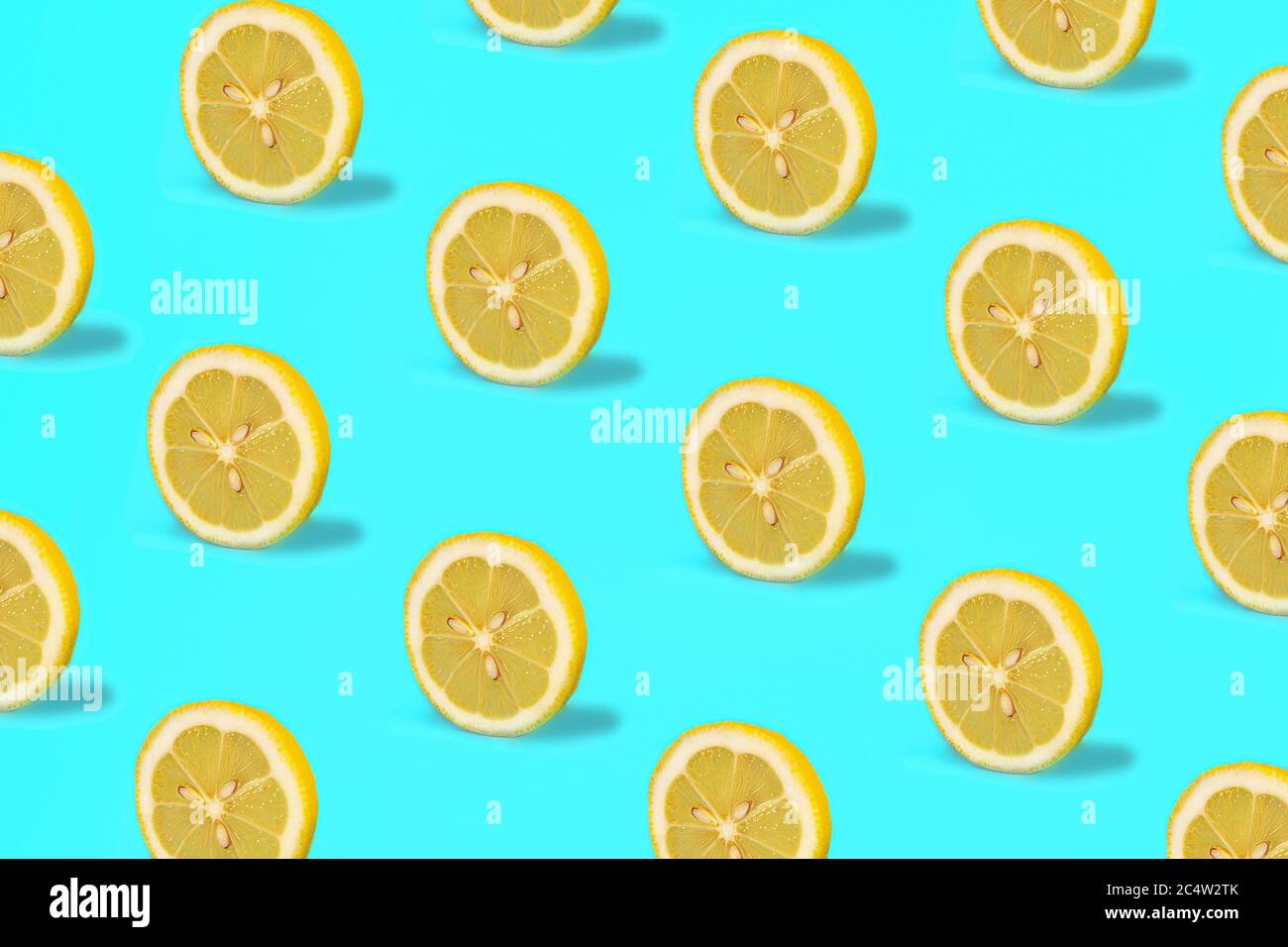Muster mit Zitronenfrüchten. Tropische abstrakte Zitrone Zitrusscheibe auf grünem Minzfarbhintergrund. Im Sommer in angesagtem Dessin. Minimales Modekonzept. Flach liegend, Nahaufnahme. Stockfoto