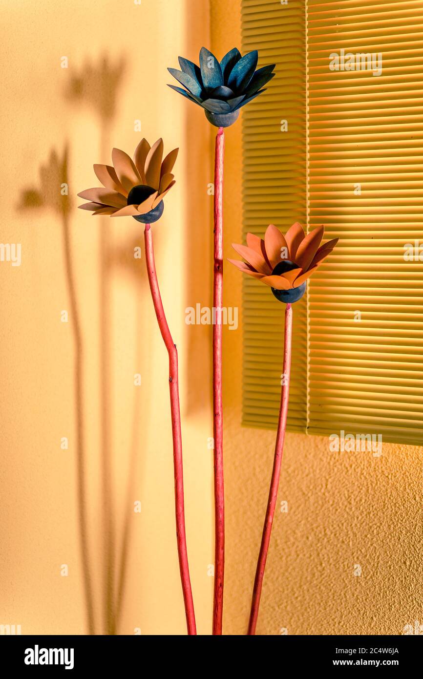 Gelber und oranger Hintergrund mit jalousien und Blumen. Wohnkultur Stockfoto