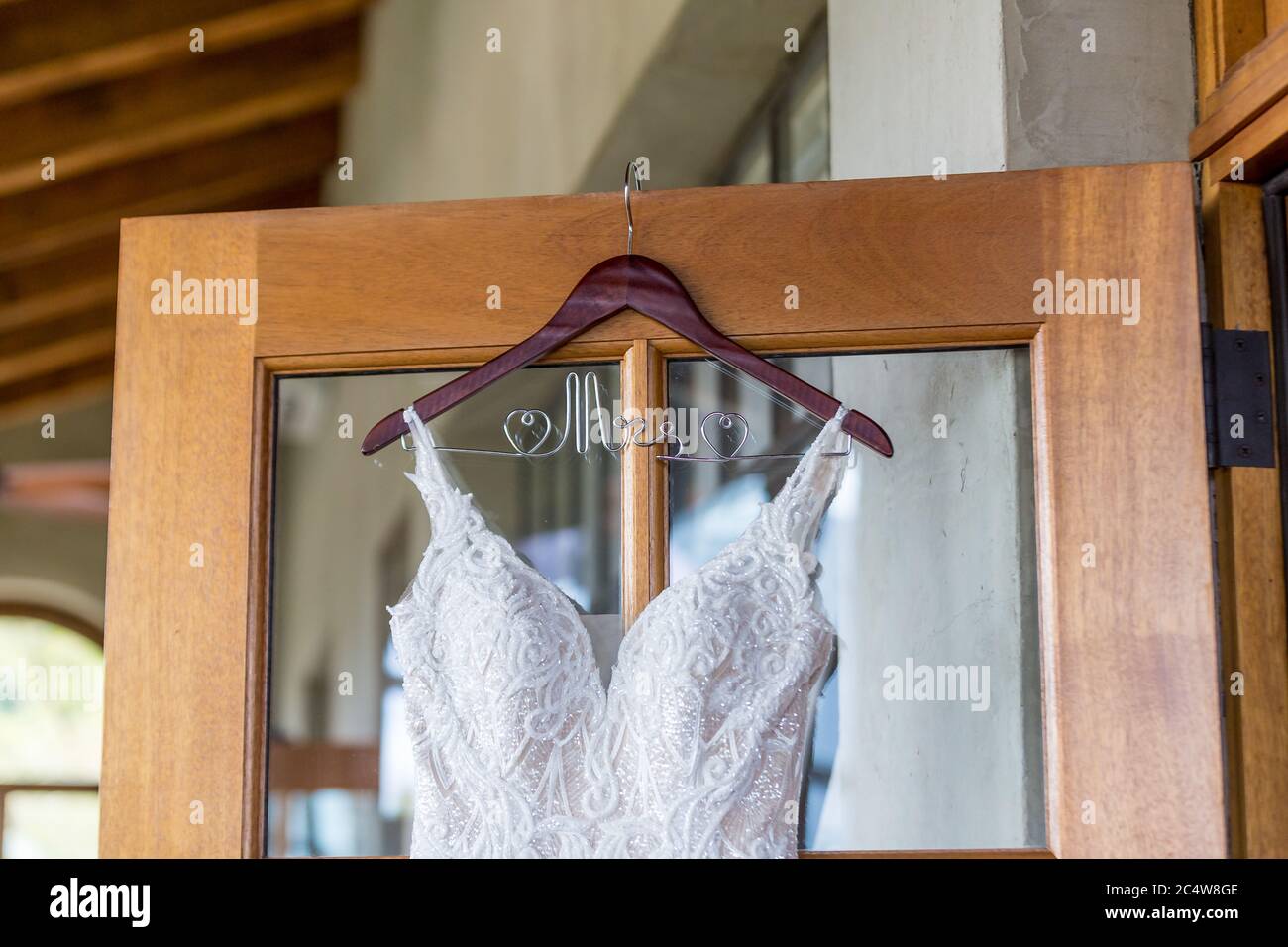 Nahaufnahme eines weißen Spitze Hochzeitskleid hängen Von der Tür Stockfoto