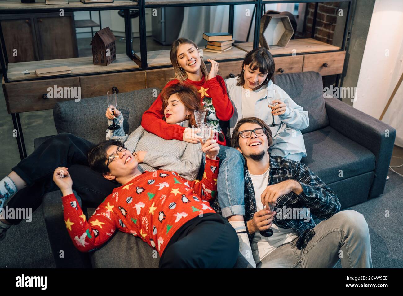 Gruppenfreunde unterhalten sich auf einer Couch im Wohnzimmer Stockfoto