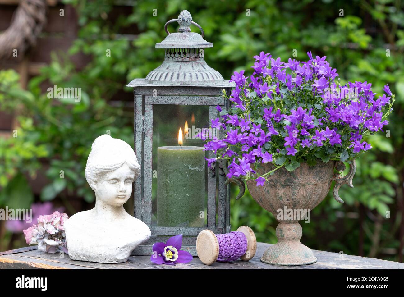 Vintage Gartendekoration mit Glockenblume, Büste und Laterne für Frauen Stockfoto