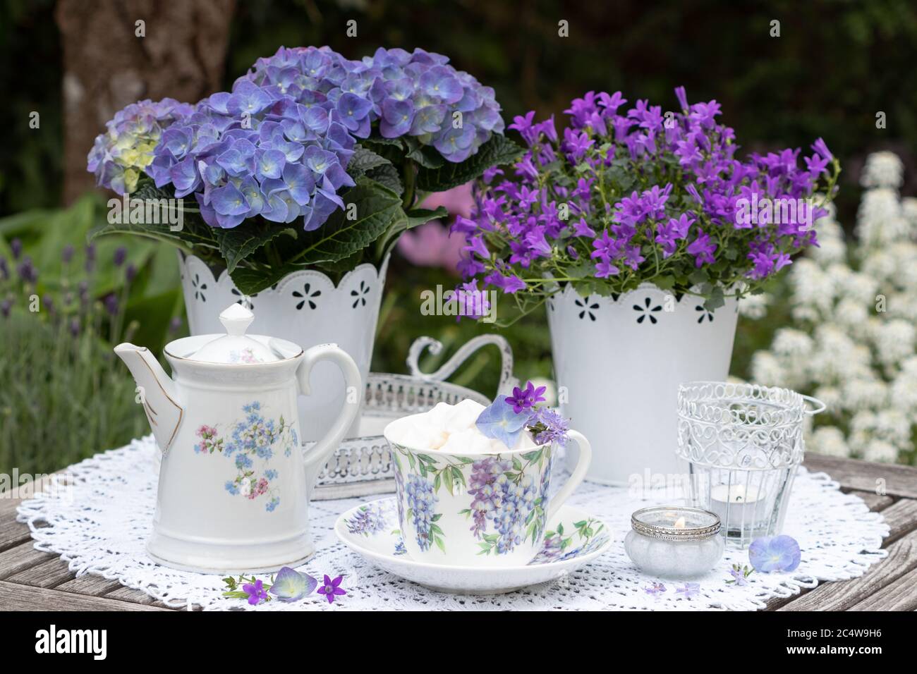 Tischdekoration mit Porzellan mit floralem Ornament und lila Blüten Stockfoto