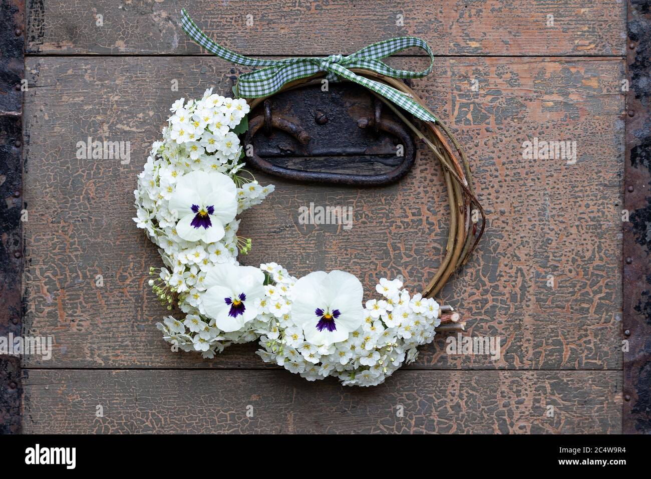 Kranz aus Viola Blumen in weiß und Girlande Spirae Stockfoto