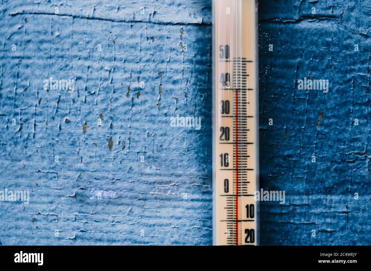 Thermometer an der alten Holzwand, Konzept des heißen Wetters Stockfoto