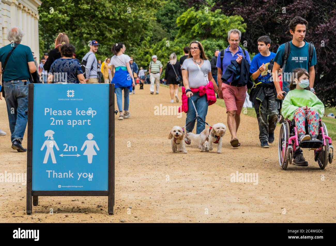 London, Großbritannien. Juni 2020. Das Schild "Keep 2m" hat eine ungewöhnliche männliche Figur mit einem griechisch-römischen Helm auf - die Menschen genießen die vielfältigen Räume von Hampstead Heath, einschließlich des Gartens des Kenwood House (English Heritage), Ausweichen zwischen starken Regenschauern und sonnigen Intervallen. Die „Lockdown“ wird nach wie vor für den Coronavirus (Covid 19) Ausbruch in London gelockert. Kredit: Guy Bell/Alamy Live Nachrichten Stockfoto