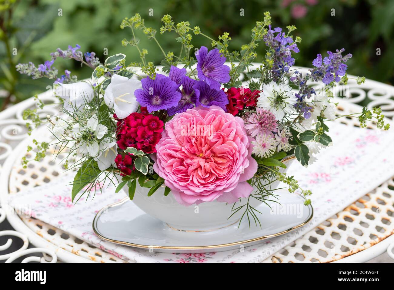 Romantisches Bouquet von Sommerblumen in Pastellfarben in Vintage-Sauce Boot Stockfoto