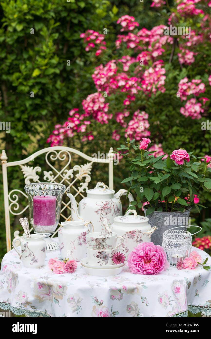 Gartenlandschaft im Sommer mit Rosen und Vintage Porzellan Stockfoto