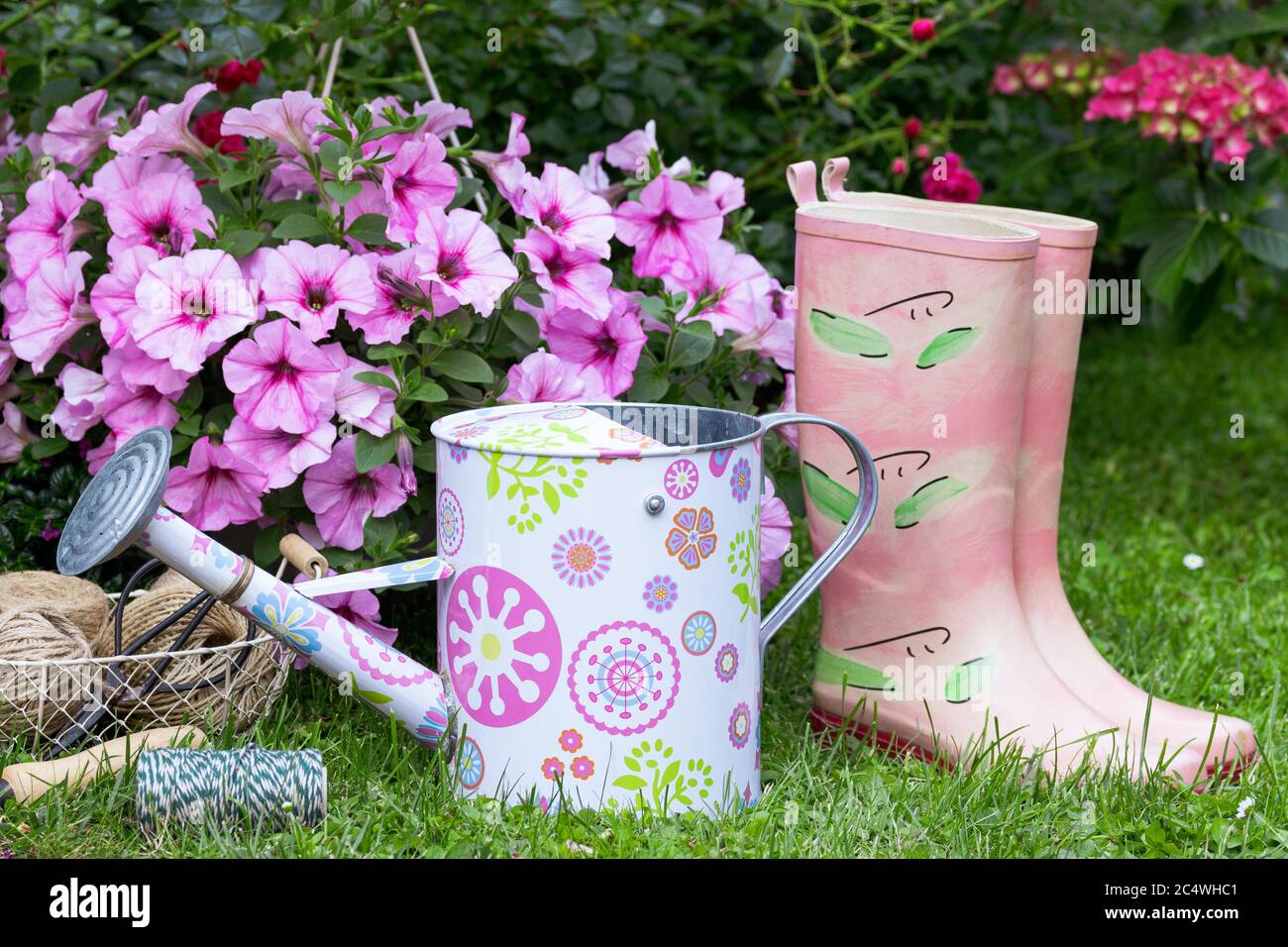 Sommer Gartendekoration mit Gießkanne, Gummistiefel und Blumen Stockfoto