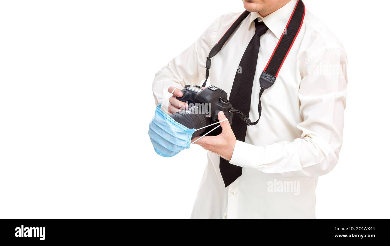 Fotograf im Hemd mit Krawatte hält dslr-Kamera mit medizinischer  Schutzmaske auf der Linse, Konzept Arbeit Fotojournalist während Quarantäne  Pandemie vir Stockfotografie - Alamy
