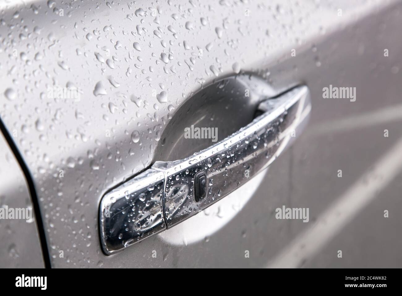 Auto Chrom Türgriff mit Fernbedienung schlüssellose Öffnung Taste Abdeckung der Wassertropfen nach dem Regen, Seitenansicht Schärfe auf der schwarzen Taste. Stockfoto