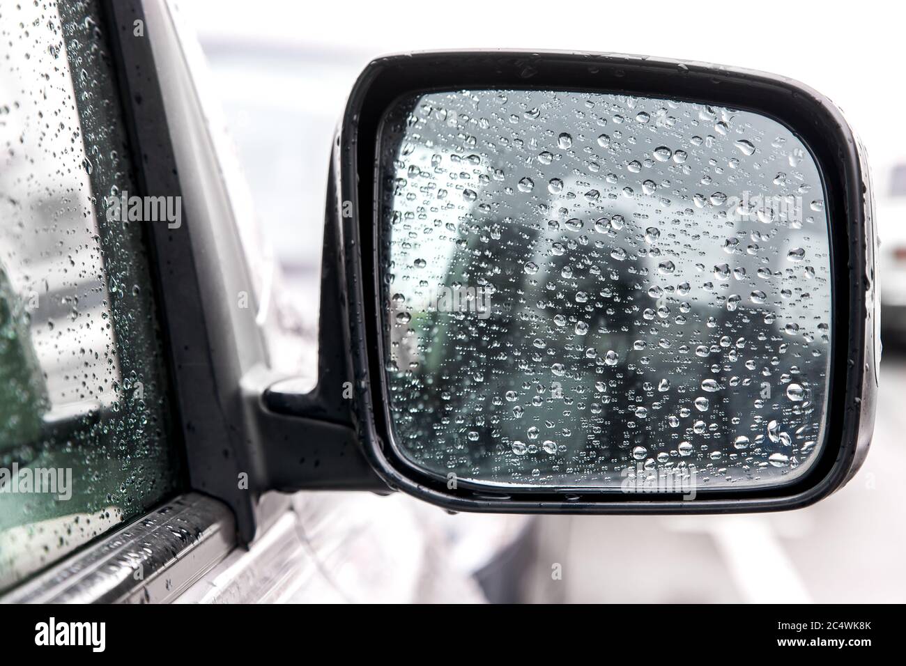 Auto Rückspiegel in den Tropfen nach dem Regen, ein nasser Spiegel eines  grauen Autos mit schwarzen Akzenten Stockfotografie - Alamy