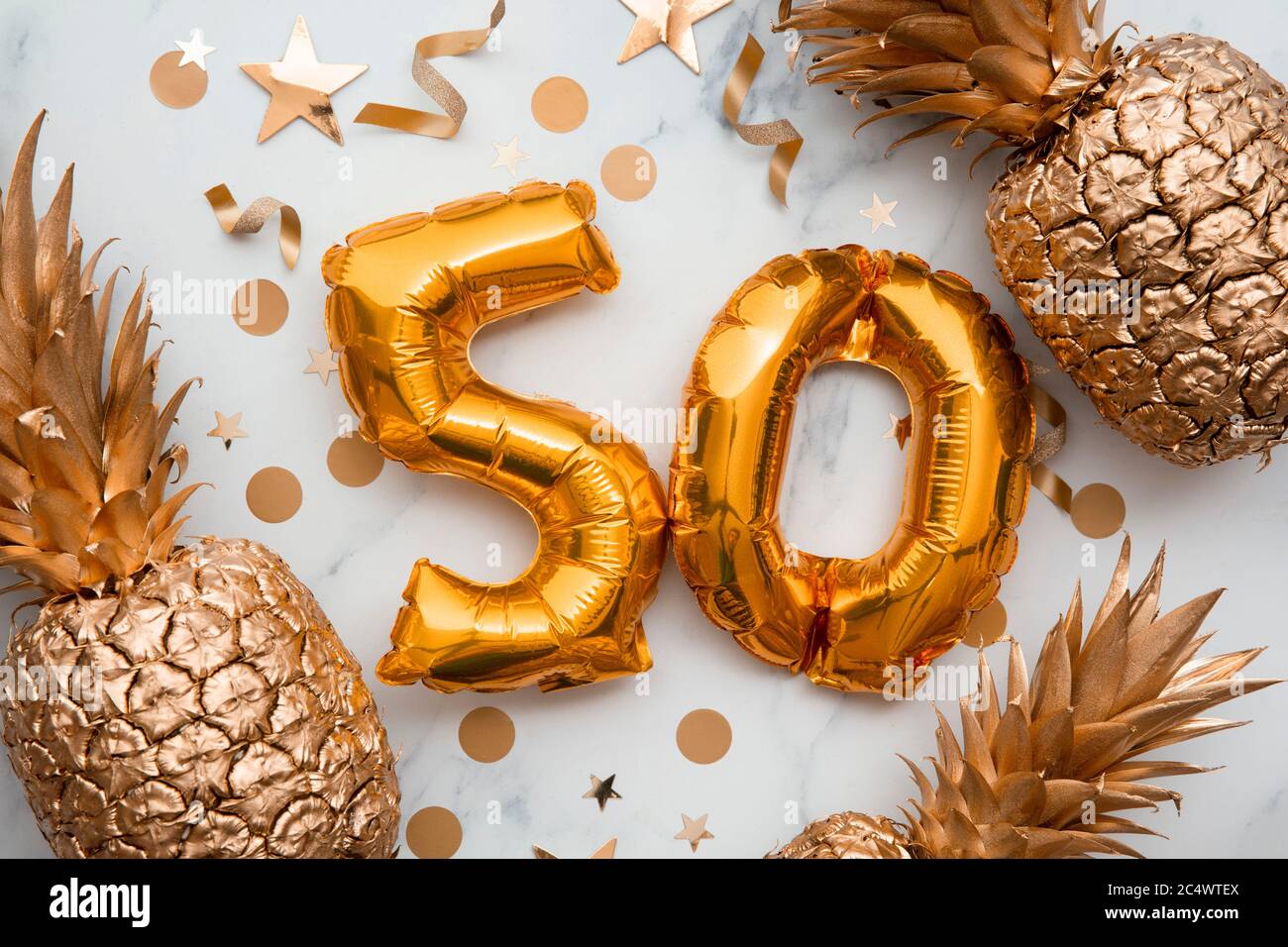 Geburtstagskarte mit goldenen Folienballons und goldenen Ananas Stockfoto