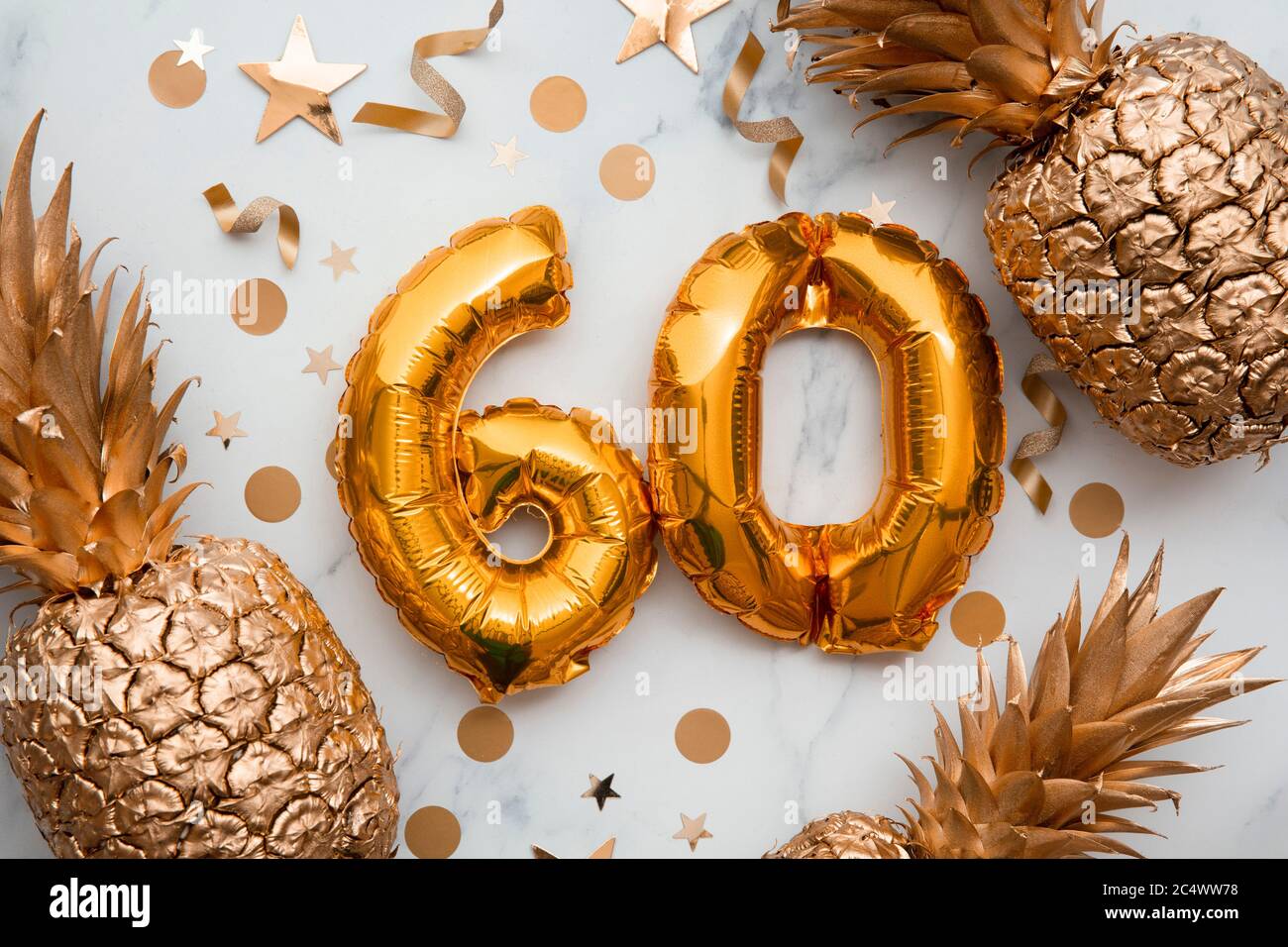 60. Geburtstag-Karte mit goldenen Folienballons und goldenen Ananas Stockfoto