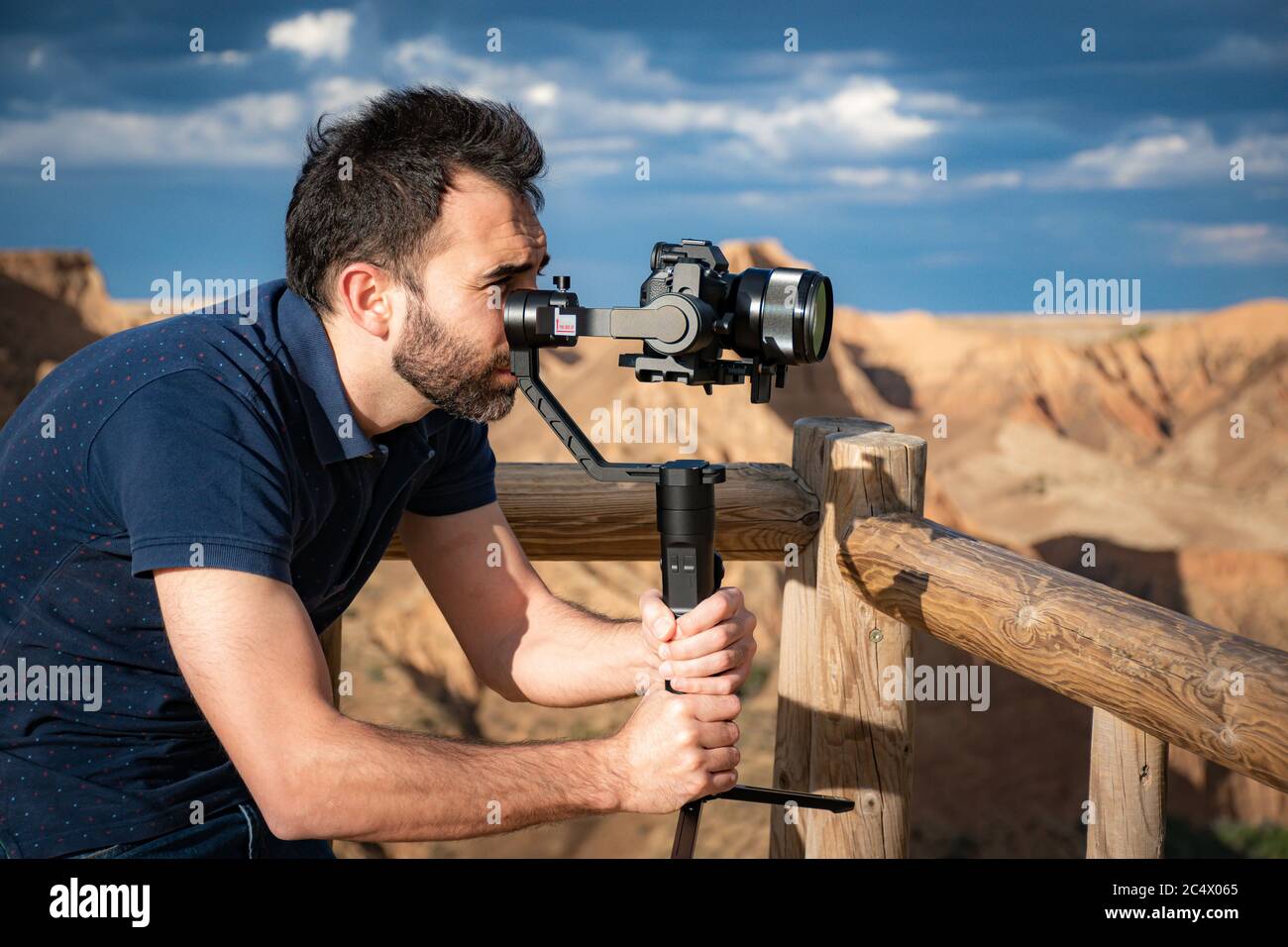 Junge Filmemacherin filmt Naturlandschaft in Canyon mit einem großen Fluss und Sümpfen Stockfoto