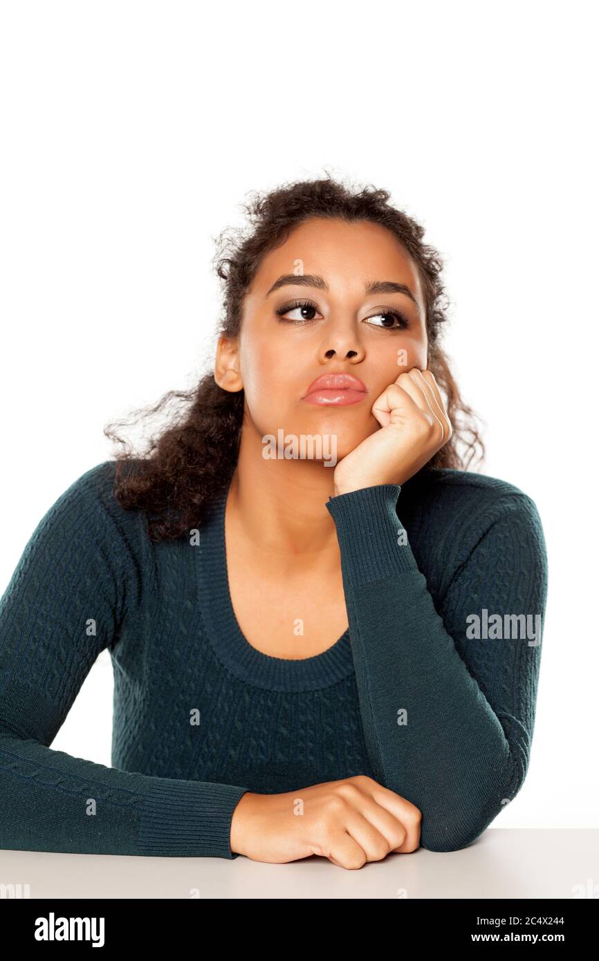 Porträt einer jungen unglücklichen dunkelhäutigen Frau auf weißem Hintergrund Stockfoto