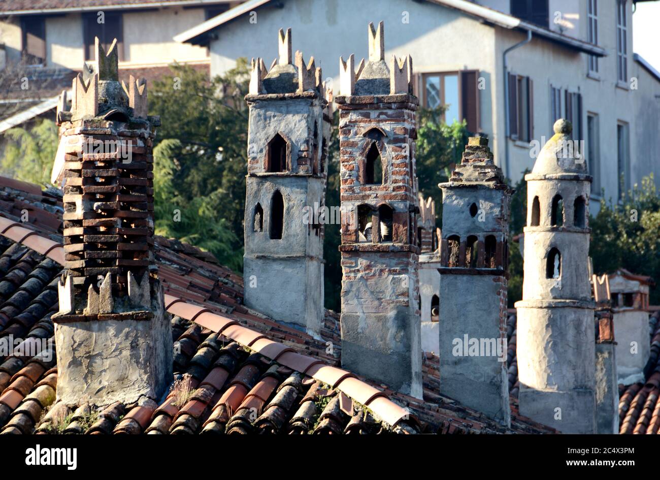 Dächer und Kamine in der Wohngegend von Bergamo Alta mit Hügeln und eleganten Villen in einer typischen und malerischen Landschaft Italiens. Stockfoto