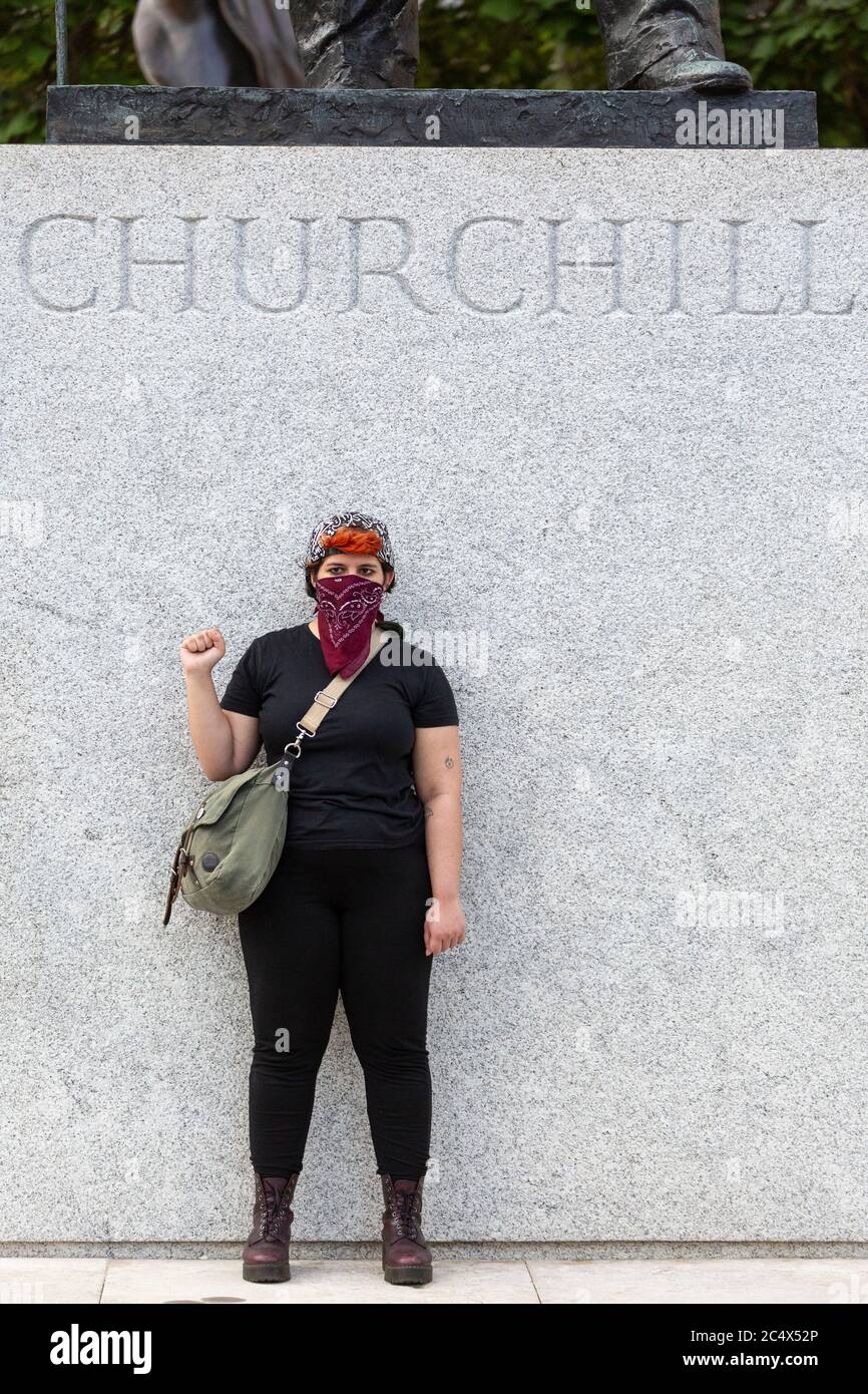 Ein junges Mädchen steht mit der Faust, die von einer Winston Churchill Statue angehoben wird, Demonstration der schwarzen Leben, Parliament Square, London, 21. Juni 2020 Stockfoto