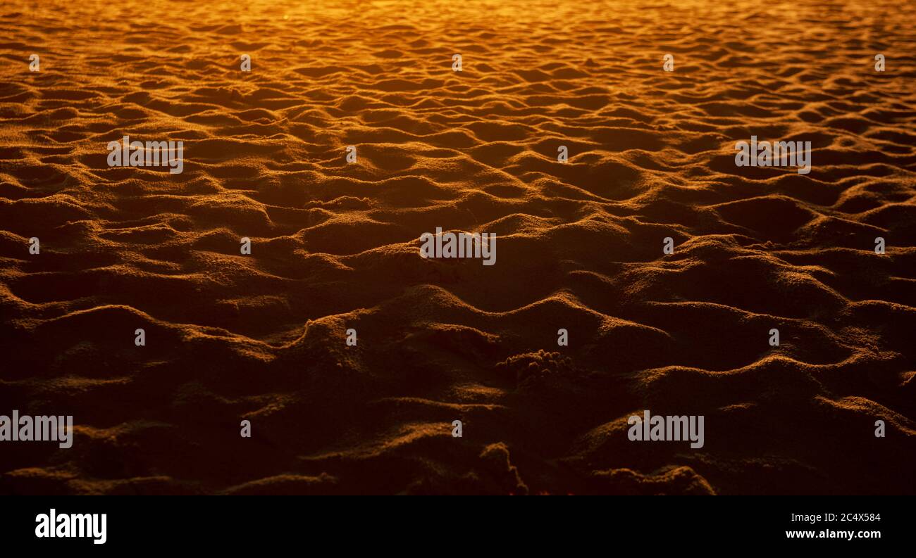 Nahaufnahme von Sandmuster eines Strandes im Sonnenuntergang. Stockfoto