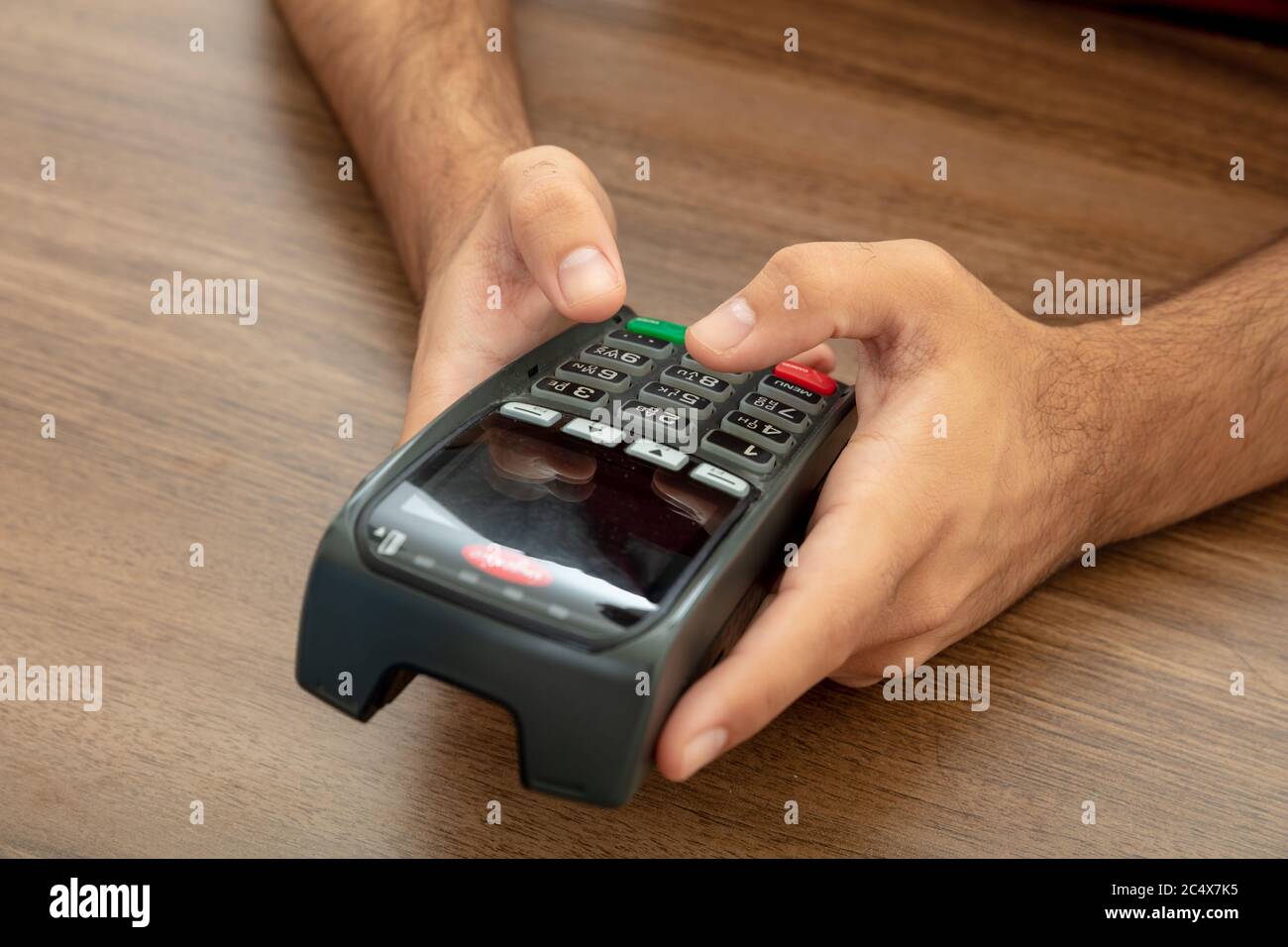 Mann hält eine Zahlung Swipe Maschine und Eingabe, Nahaufnahme. Kreditkartenleser, Kassenterminal-Bezahlkonzept. Stockfoto