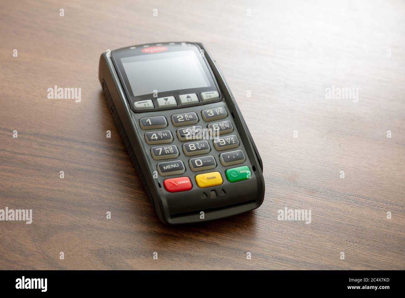 POS-Terminal isoliert auf Holzhintergrund, Kopierraum.Terminal-Kassenautomat für kontaktloses Bezahlen mit Kreditkarte. Bankausstattung, NFC Stockfoto