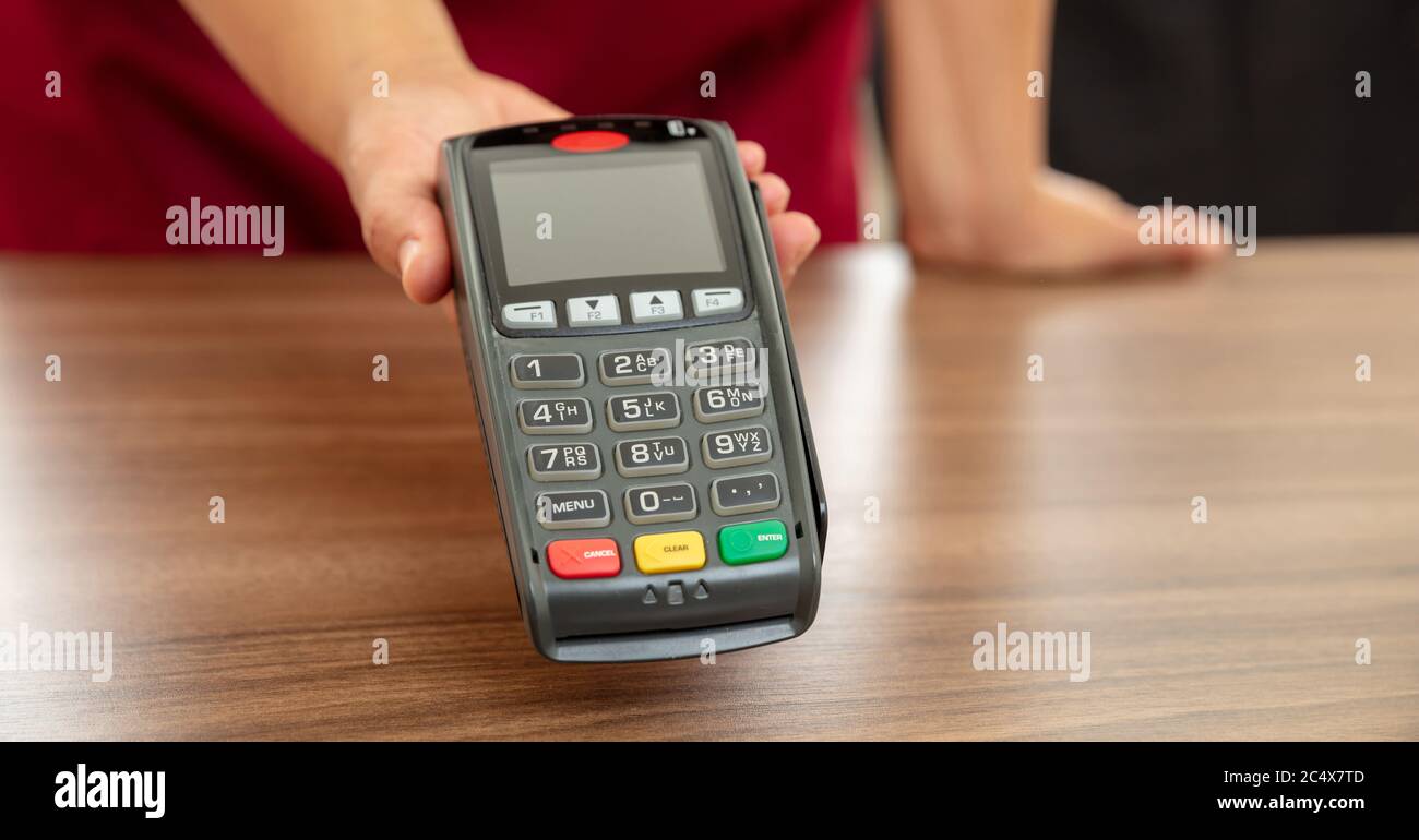 Kasse bietet POS-Terminal für die Zahlung mit Kreditkarte. Banking, Shopping und kontaktloses Bezahlen mit NFC-Technologiekonzept. Stockfoto