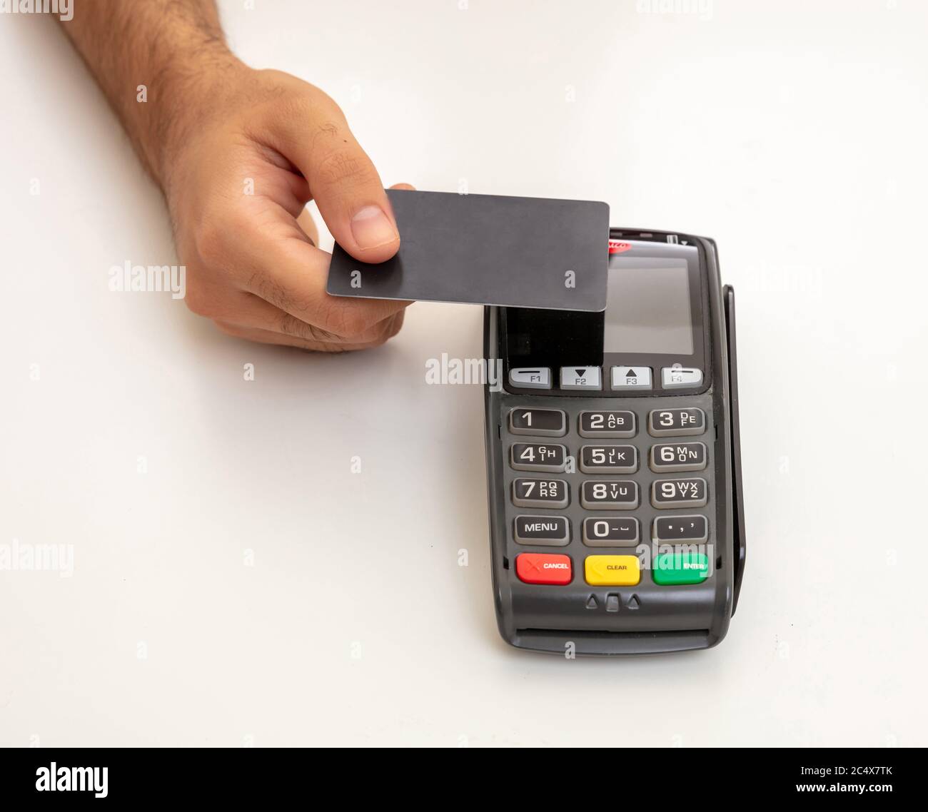 Bezahlung mit NFC-Technologie. Hand hält eine leere Kreditkarte über einem POS-Terminal isoliert auf weißem Hintergrund.Terminal Kasse Maschine für cont Stockfoto