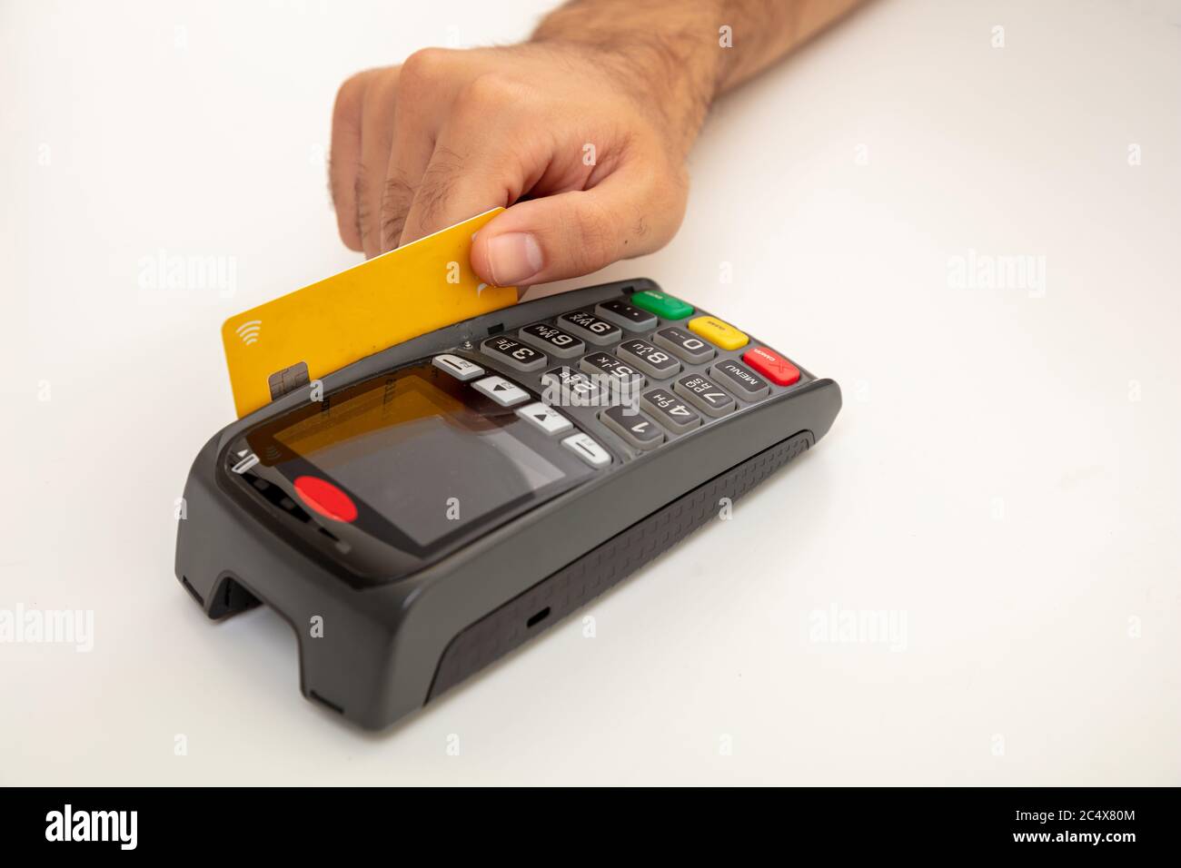 Hand wischen eine Kreditkarte in einem POS-Terminal isoliert auf weißem Hintergrund, Nahaufnahme.Terminal-Kasse Maschine für bargeldlose Zahlung. Stockfoto