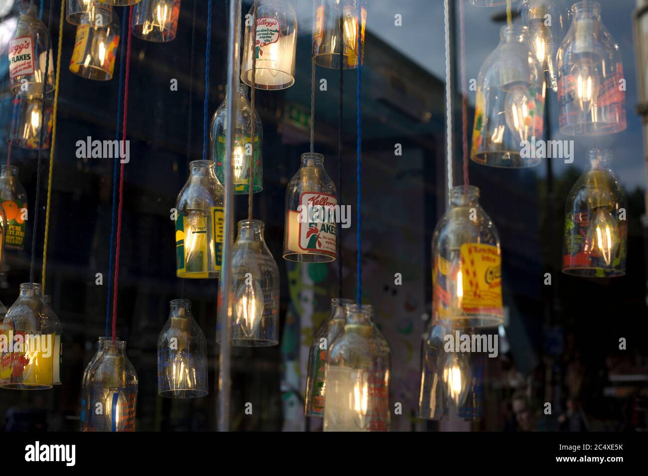 Markenflaschen als Leuchten in Schaufenstern. Kreative Fenster, kreative Displays Stockfoto