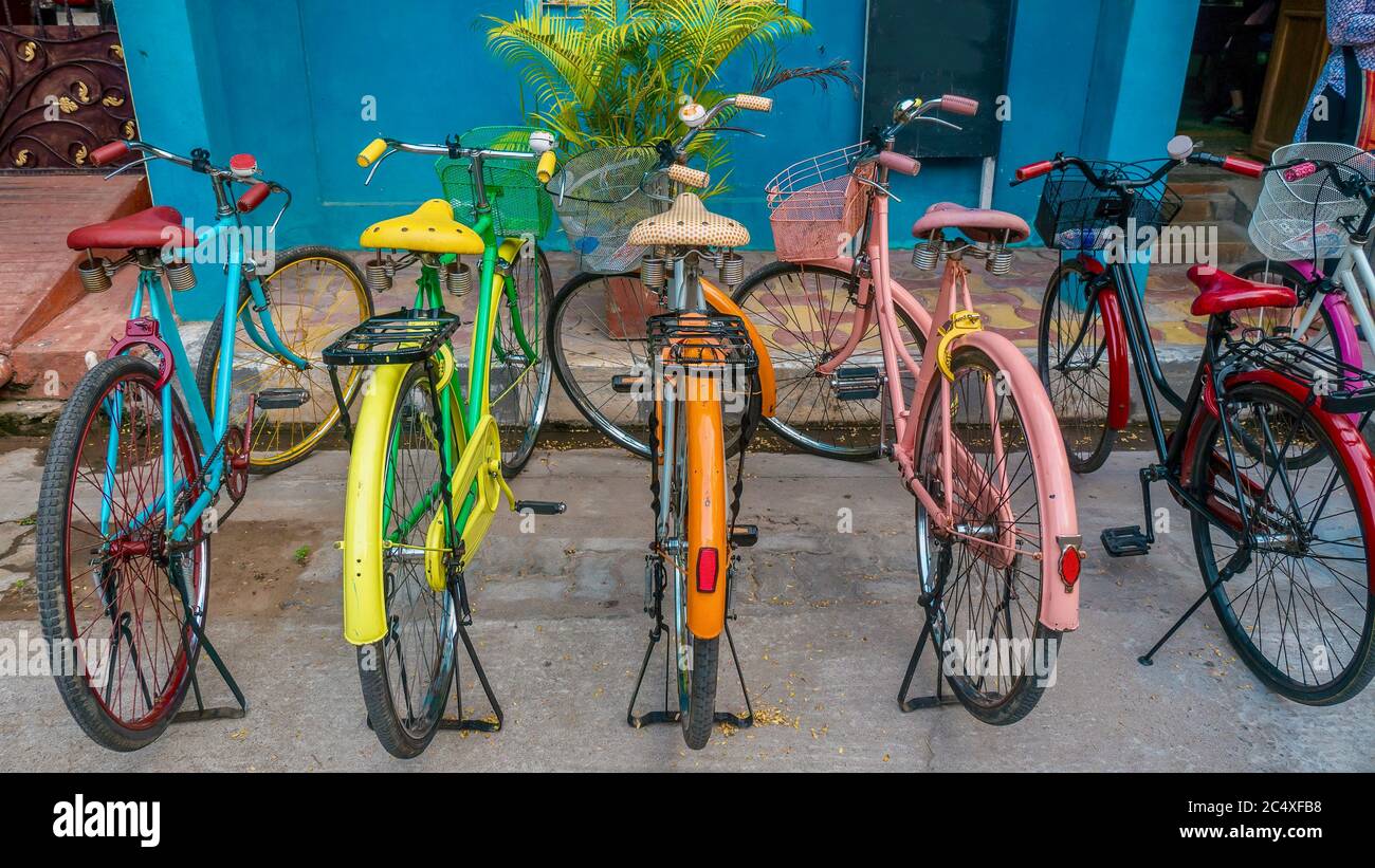 Eine Reihe von Vintage-Fahrräder in hellen Farben gemalt, geparkt auf einer Straße in Pondicherry, Indien. Stockfoto