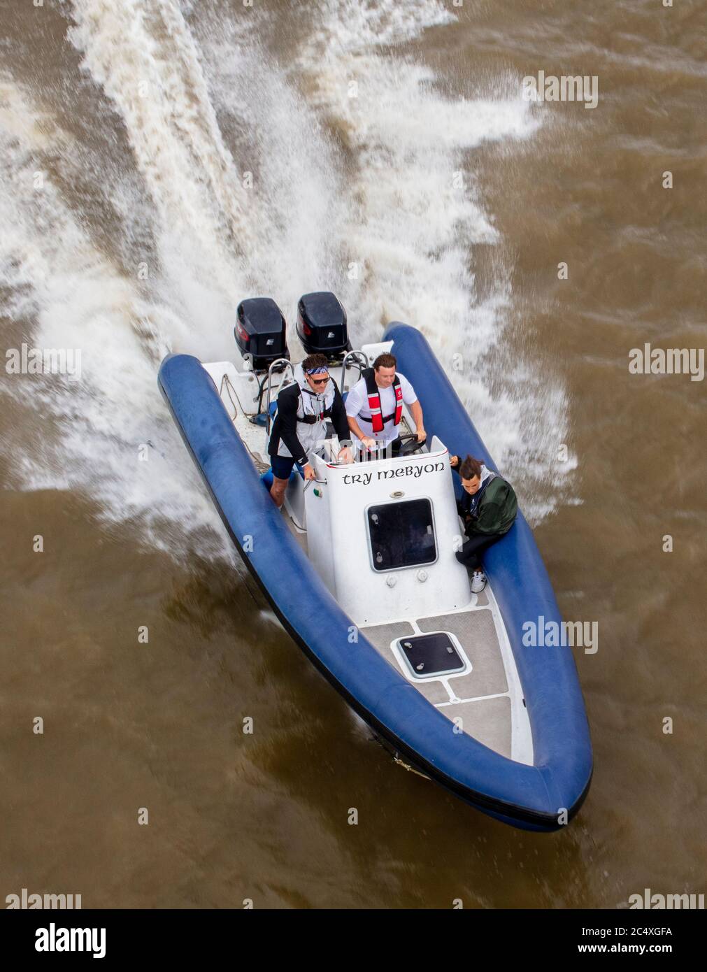 Motorboot/Schnellboot mit zwei Männern auf der Themse, die Wake oder Wash produzieren, von Battersea Bridge Stockfoto