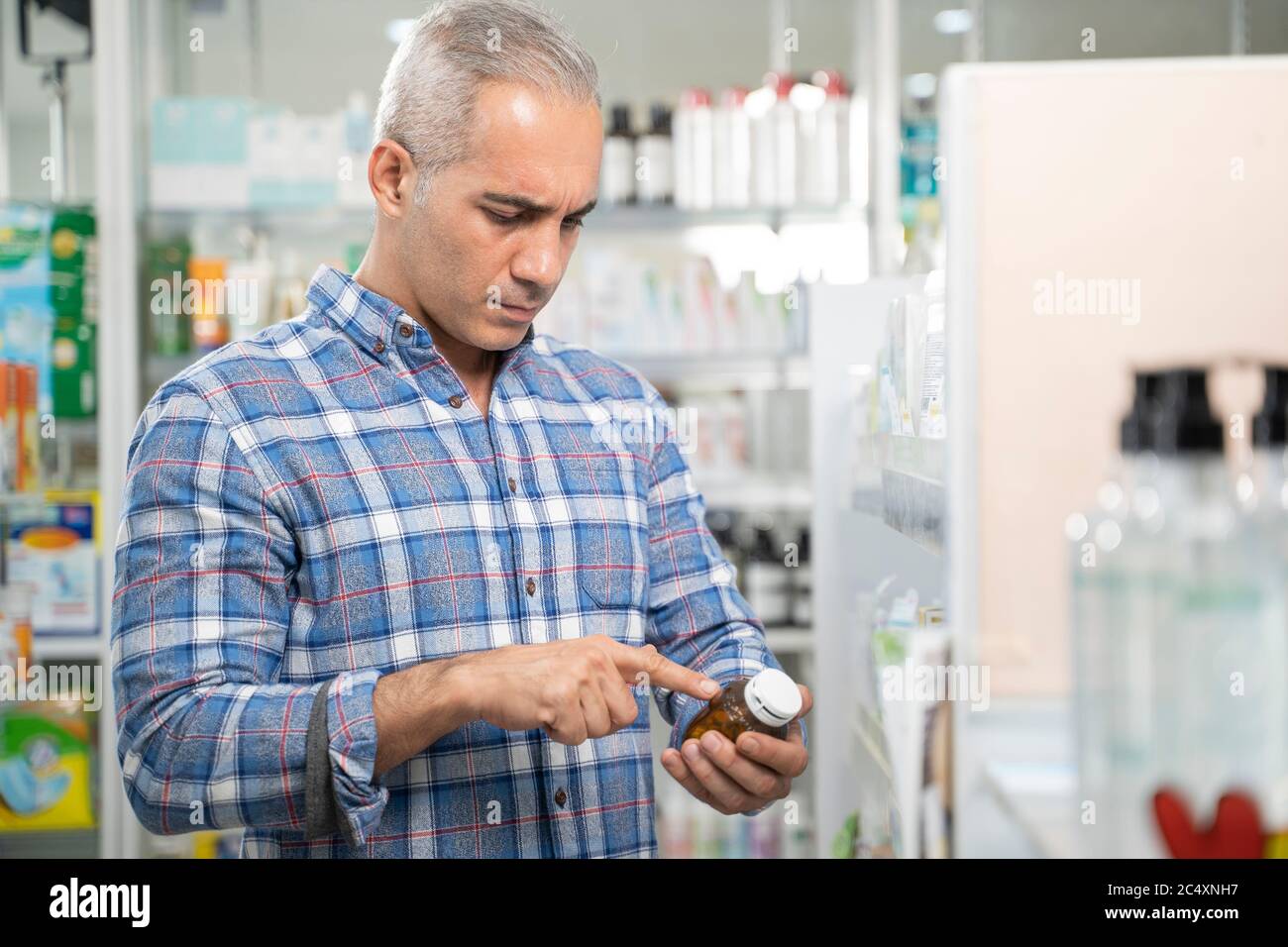 Männer lesen Etikett der Medizin Flasche. Stockfoto