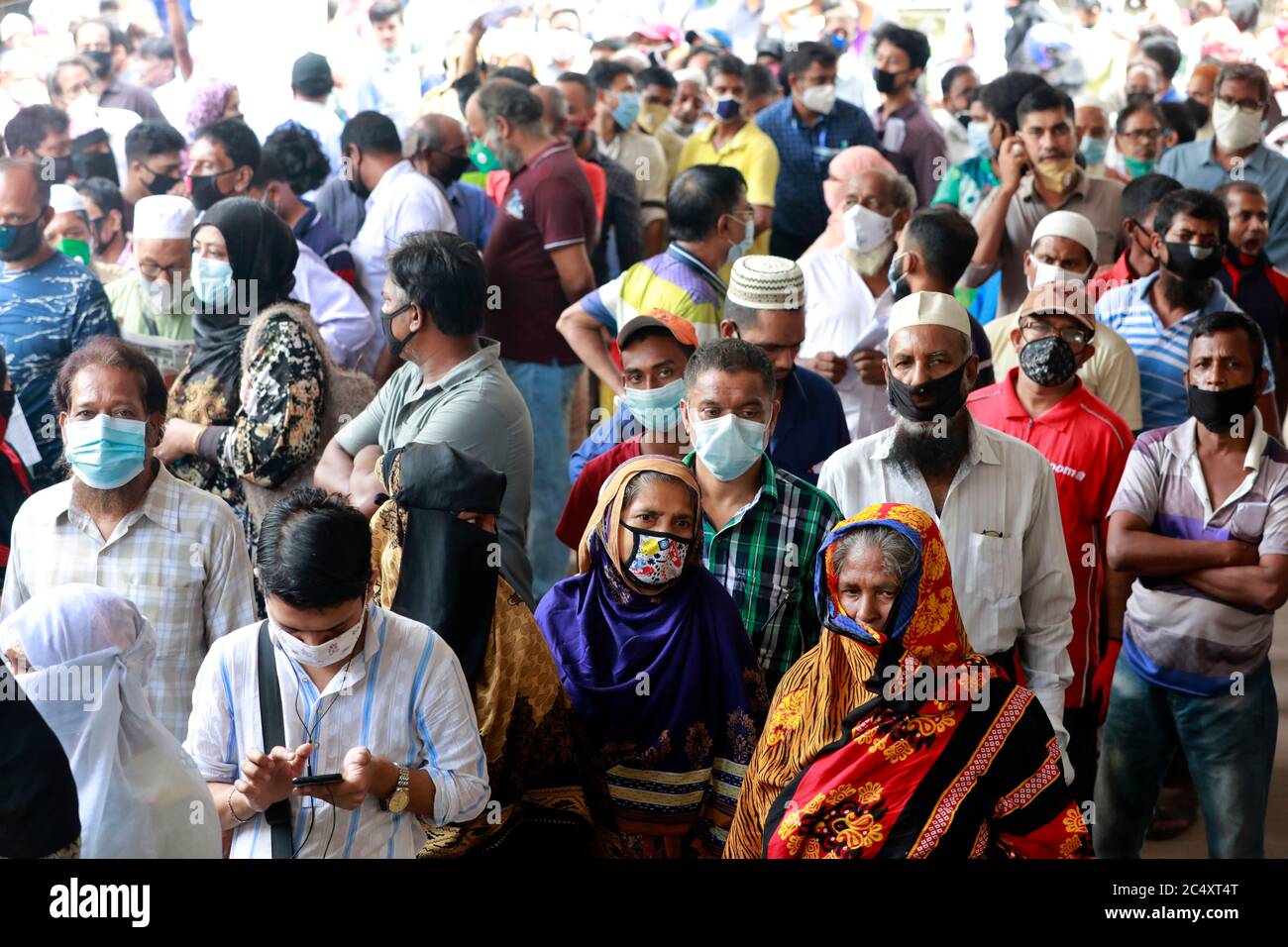 Dhaka, Bangladesch - 29. Juni 2020: Ohne die soziale Distanzierung aufrecht zu erhalten, stehen die Menschen in Schlangen, um ihre Wasserrechnungen im Büro von Jatrabari zu bezahlen Stockfoto