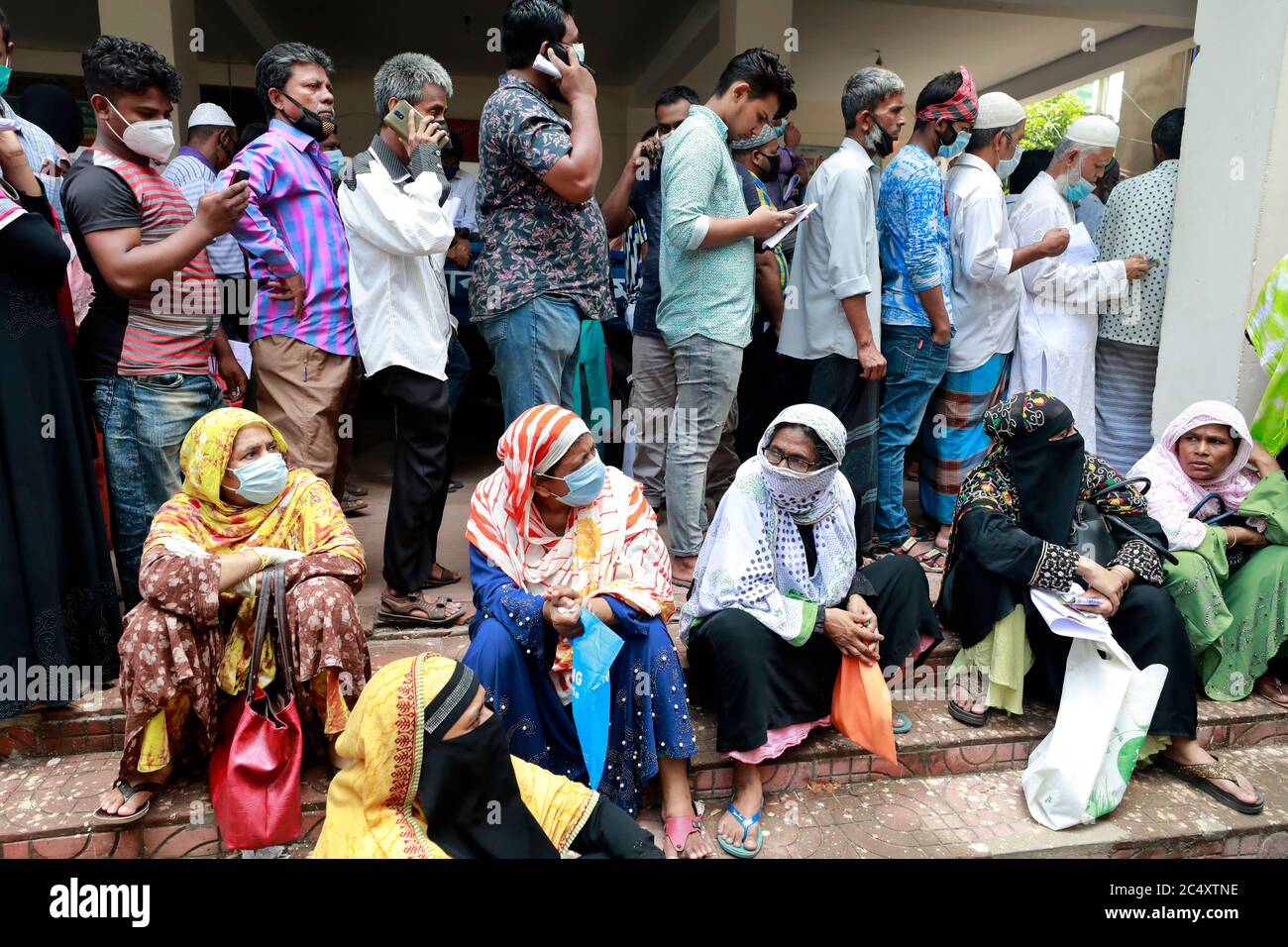 Dhaka, Bangladesch - 29. Juni 2020: Ohne die soziale Distanzierung aufrecht zu erhalten, stehen die Menschen in Schlangen, um ihre Wasserrechnungen im Büro von Jatrabari zu bezahlen Stockfoto