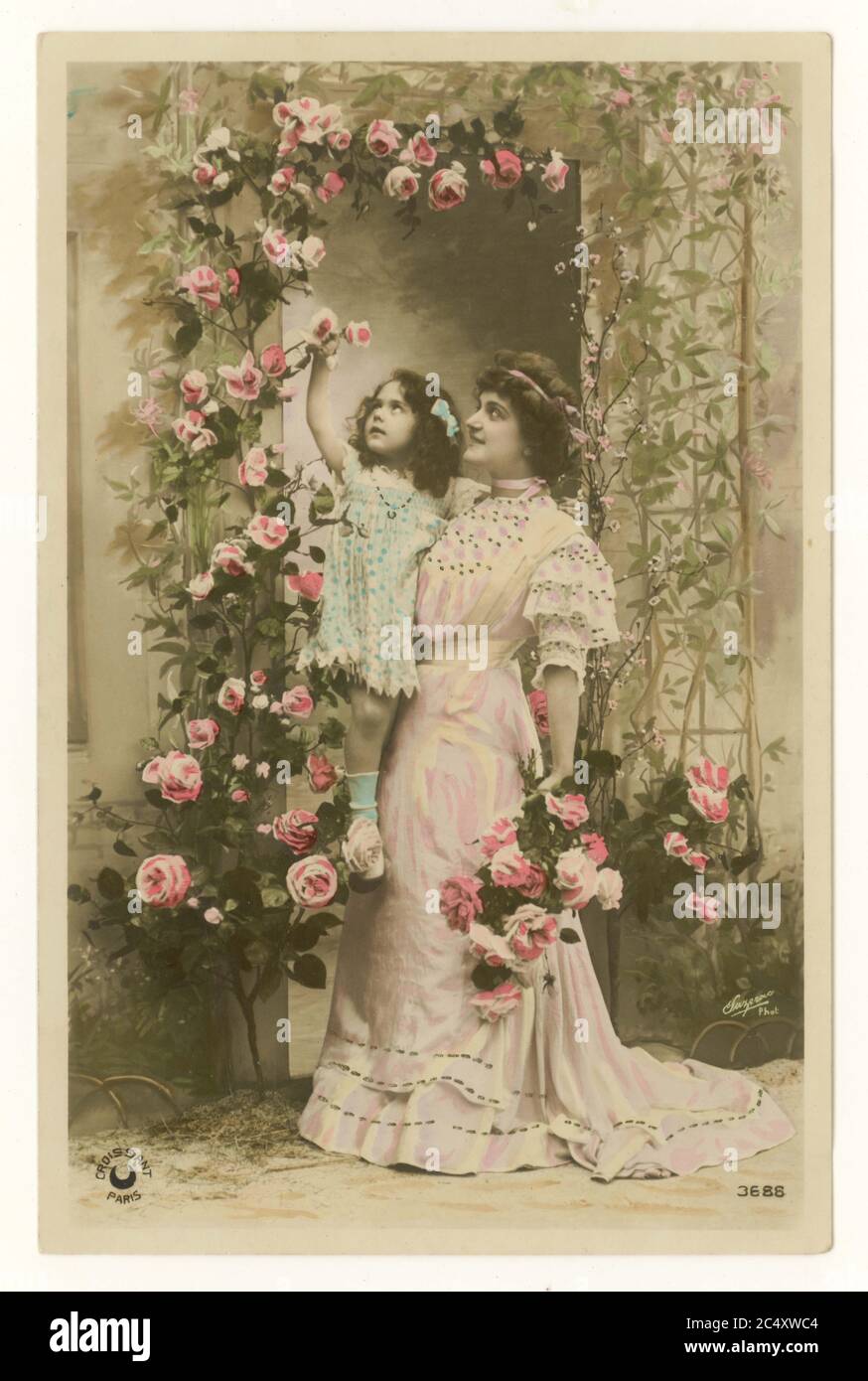 Anfang des 20. Jahrhunderts Französisch sentimental getönte Grußkarte - Mutter und süße Tochter - die Mutter hält ihre Tochter bis zu Rosen, Frankreich, um 1912 Stockfoto