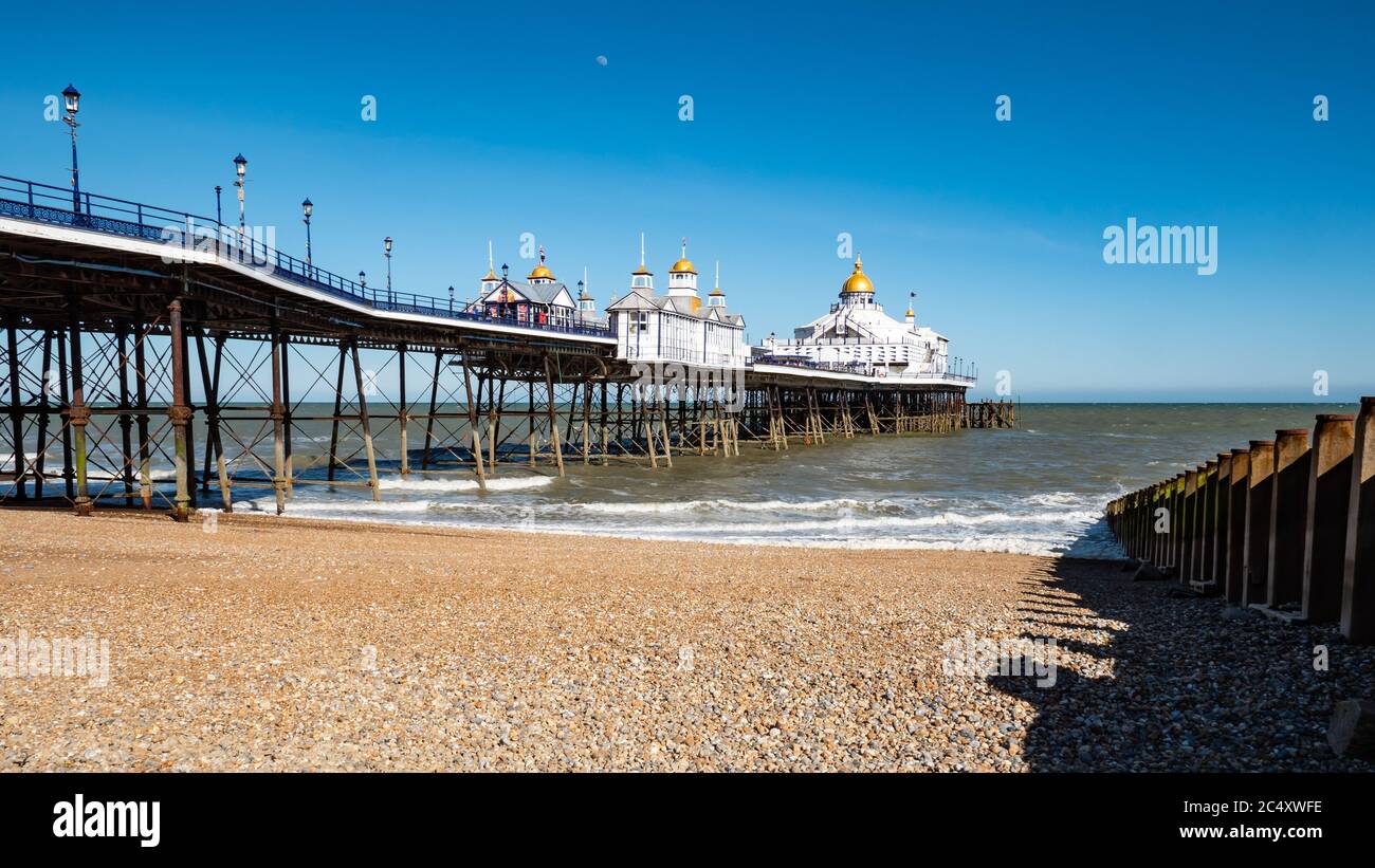 Eastbourne Pier und Kiesstrand, East Sussex, England. Der Landmark Pier im beliebten englischen Badeort an einem hellen und sonnigen Frühlingstag. Stockfoto