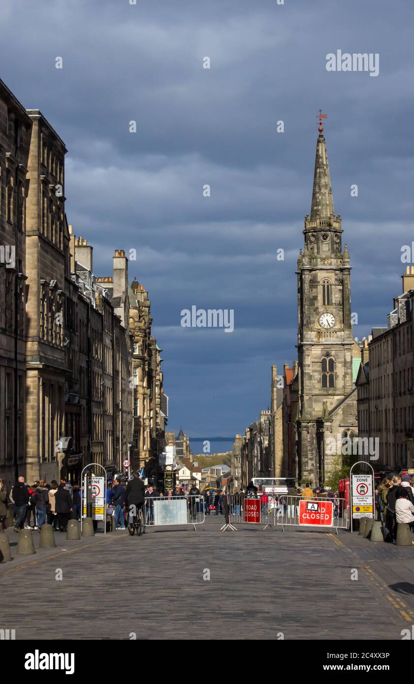 Eine Royal Mile im Sonnenlicht in der Altstadt von Edinburgh, mit dunklen, stürmischen Wolken im Hintergrund Stockfoto