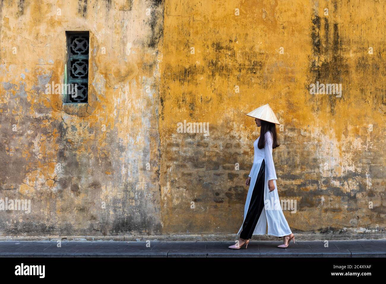 Vietnamesische Mädchen Im Traditionellen Kleid Vorbei Gelbe Wand Stockfoto