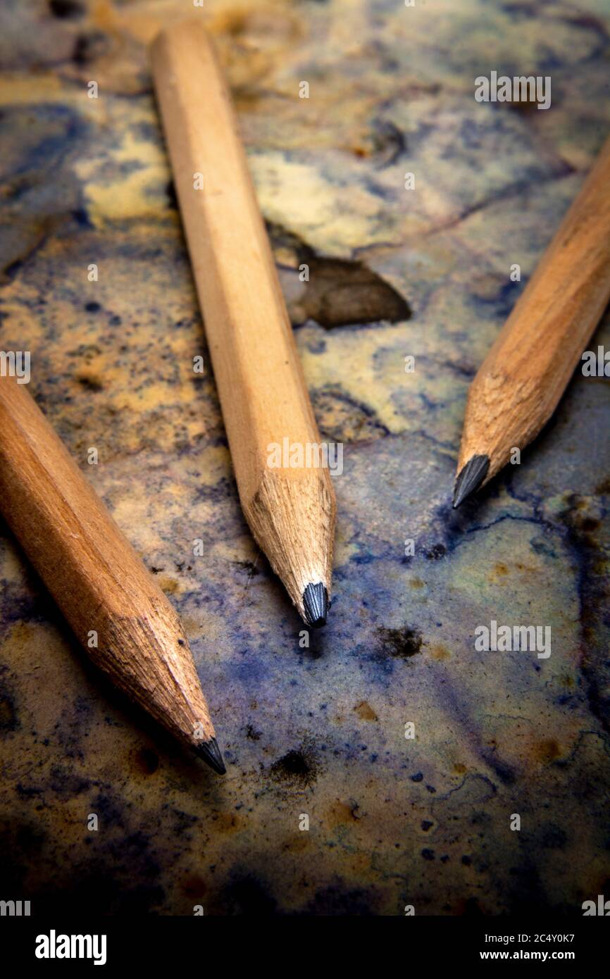 Vertikale Nahaufnahme von Bleistiften auf einem Papier mit Tintenmarkierungen Vertikale Nahaufnahme von Bleistiften auf einem Papier mit Tintenmarkierungen Stockfoto