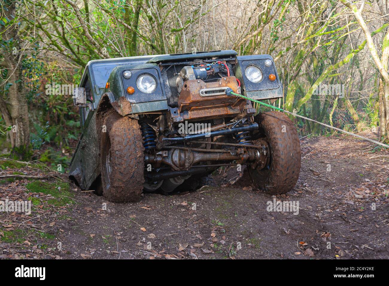 Land Rover in voller Off-Road-Modus Form Winching eine steile Bank zu pflügen durch den Schlamm Stockfoto