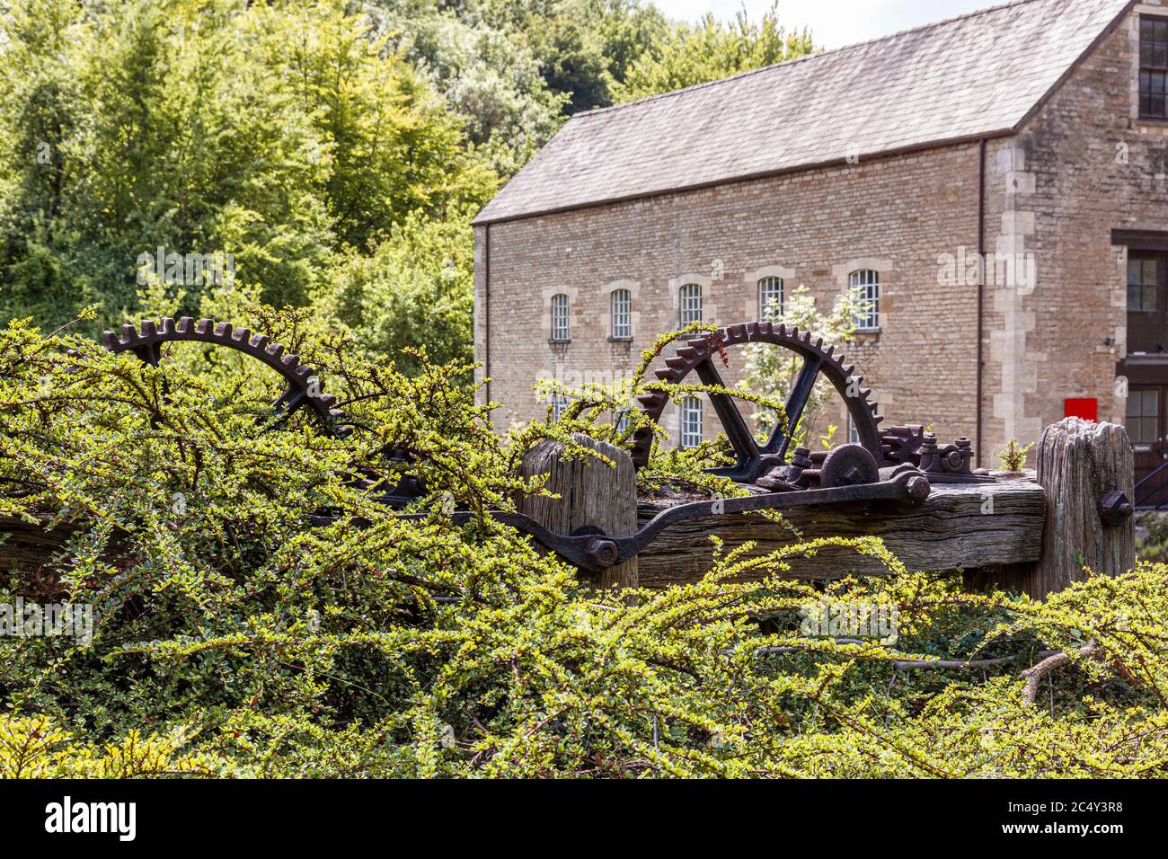 Alte Maschinen an der Themse und Severn Canal neben Belvedere Mill (auch bekannt als Tayloes Mill) auf dem Fluss Frome in den Stroud Tälern bei Chalford Stockfoto