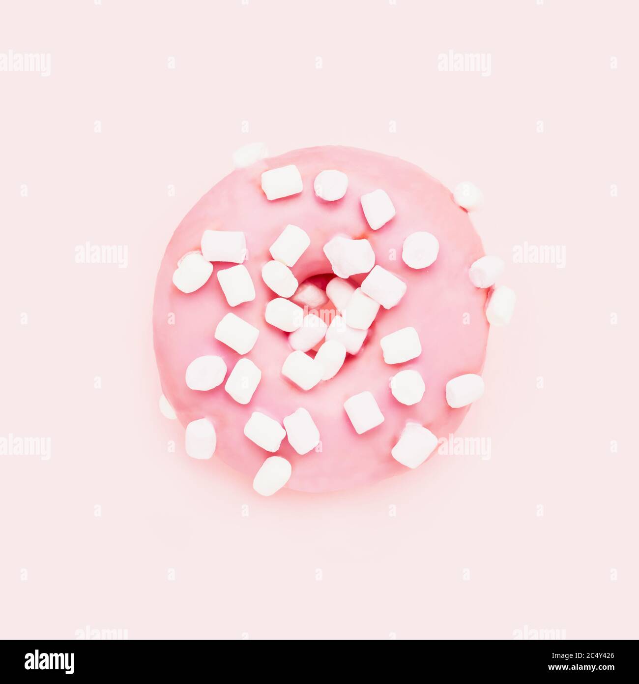 Rosa Donut mit weißen Streuseln auf rosa Hintergrund. Draufsicht, Kopierbereich für Text Stockfoto