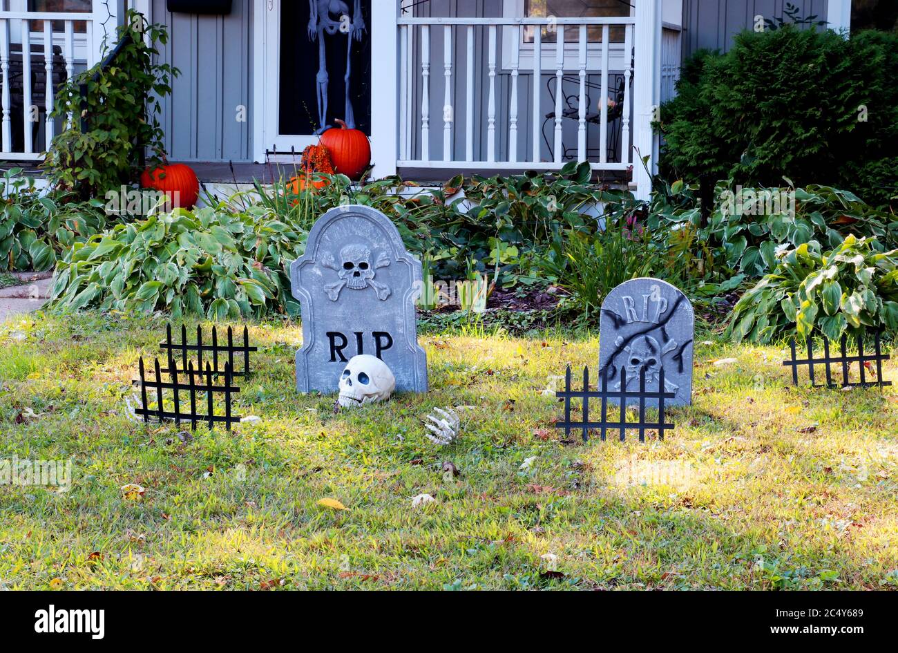 Vorgarten des privaten Hauses mit gefälschten Schädel, Knochen Hände, Grabsteine und Roste, Kürbisse auf der Veranda für eine alte amerikanische Trick-or-Treat Hallo dekoriert Stockfoto